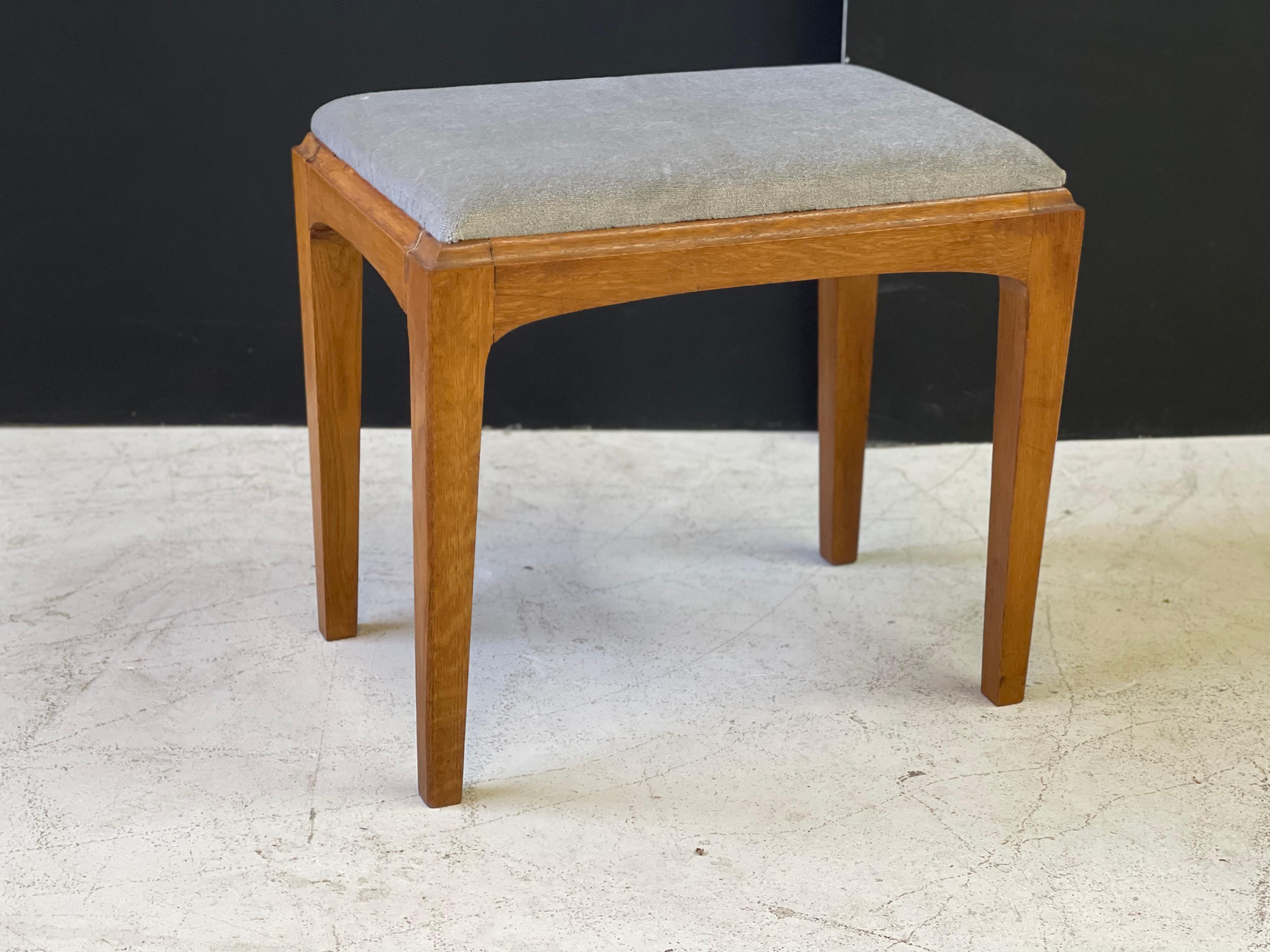 This amazing vintage stool is part of the line designed by John and Sylvia Reid for British manufacturer 'Stag Furniture' in the 1950's. The stool features a contemporary design with tapering block legs and arched aprons. It is made of a light oak