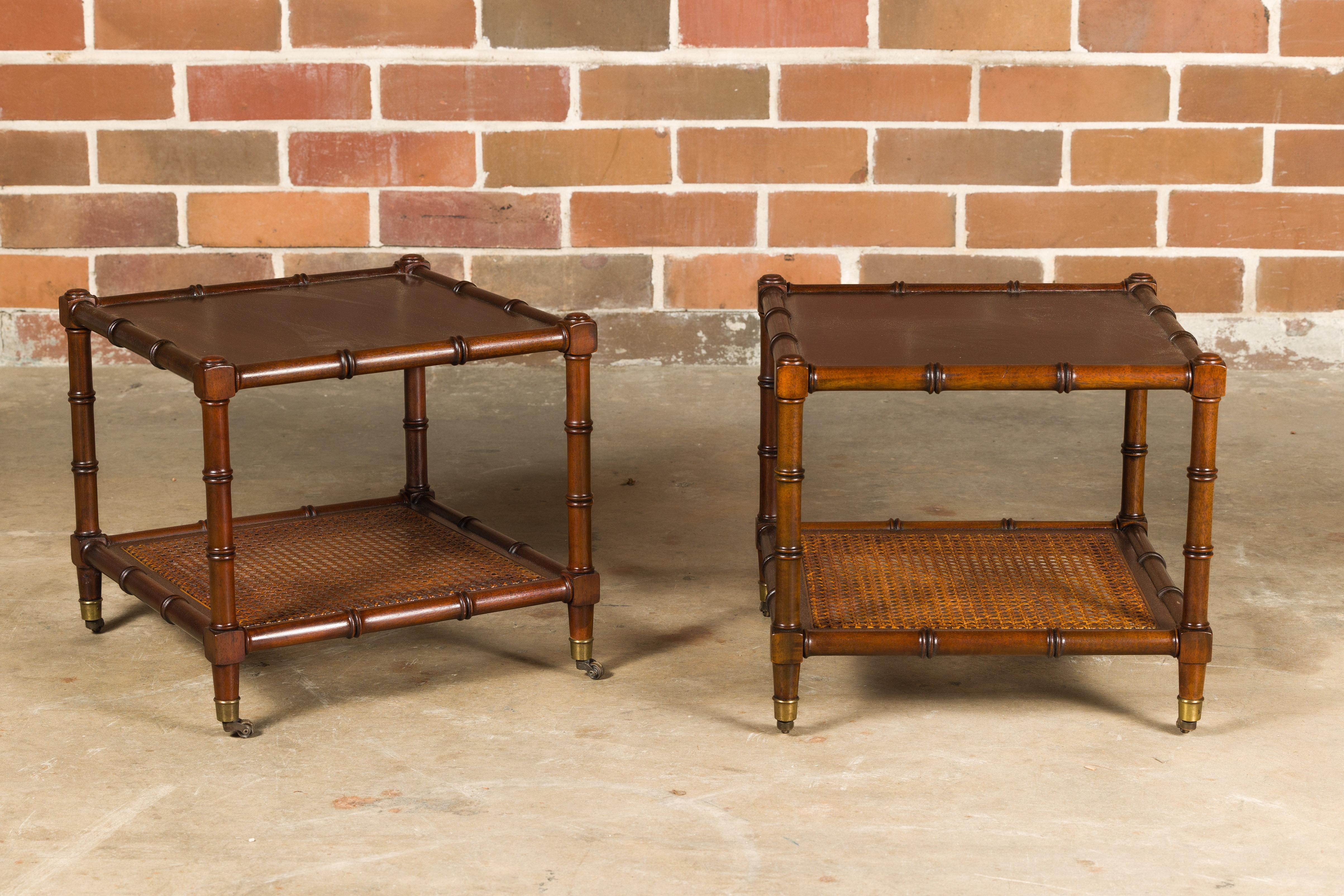A pair of English Midcentury faux bamboo walnut low side tables on casters with cane shelves. This pair of English Midcentury side tables effortlessly combines functionality with stylish design. Crafted with a faux bamboo walnut frame, they showcase