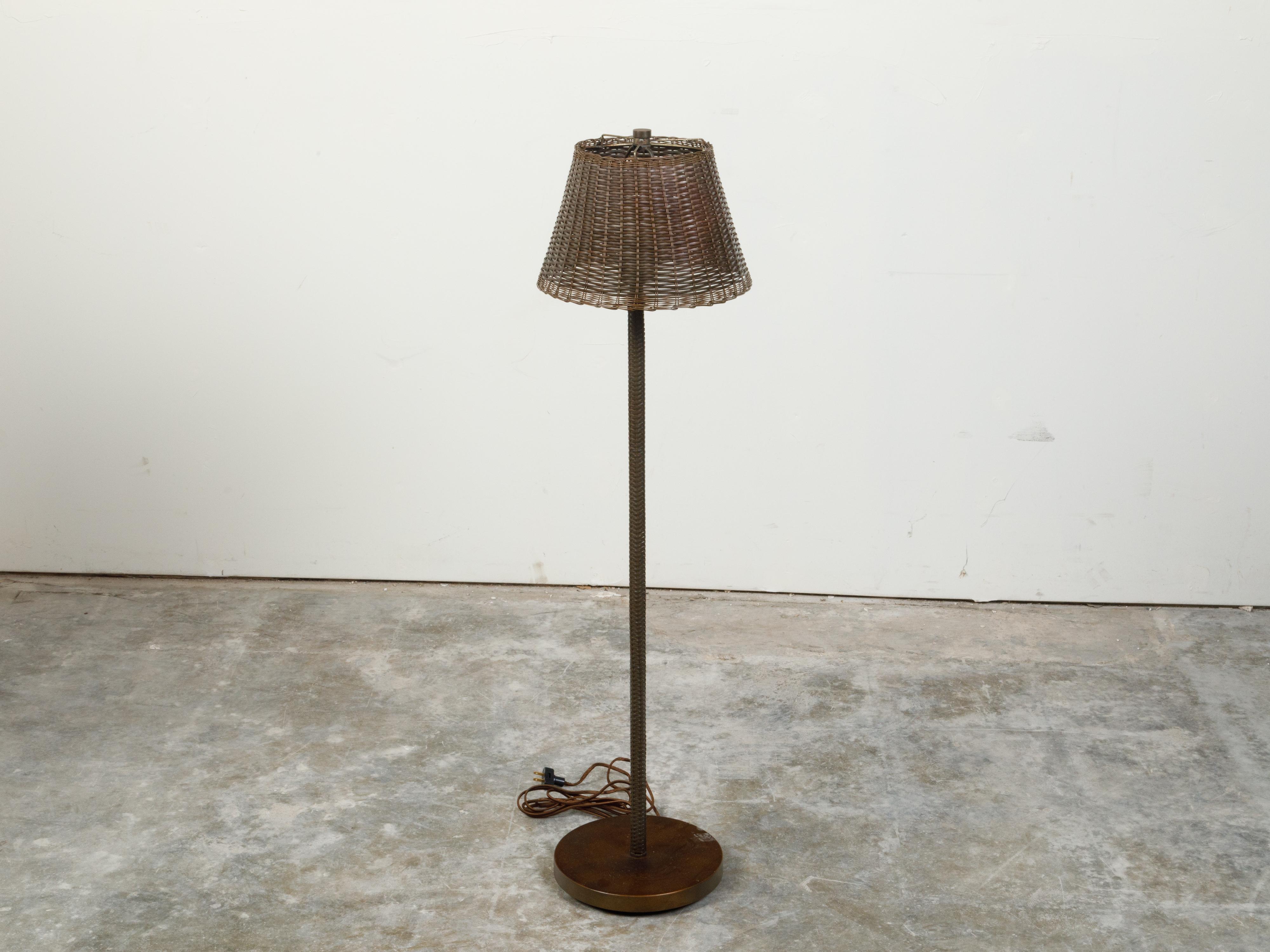 An English vintage woven basket adjustable floor lamp from the mid 20th century with single light, wired for the US. Created in England during the midcentury period, this rustic floor lamp features a woven basket securing a single light. Newly wired