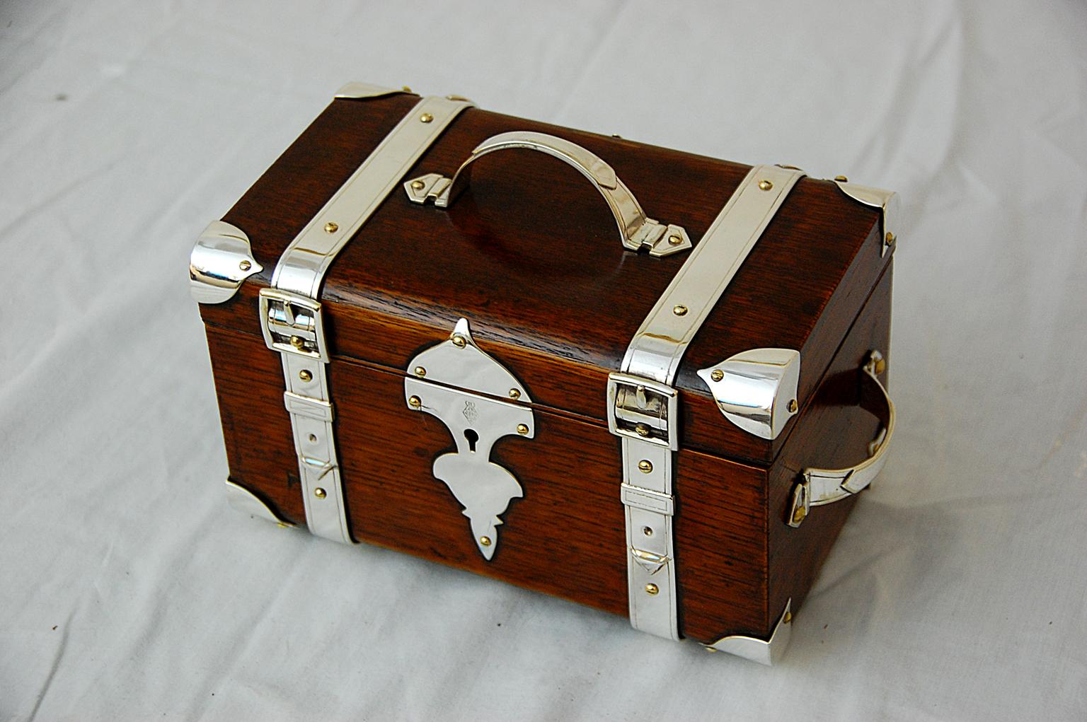 English military tobacco box in oak with silverplate corners, handles and belting. This superb quality box is registry dated 1879 and is marked with the broad arrow, which signifies an official war office purchase. The wonderful detailing of the