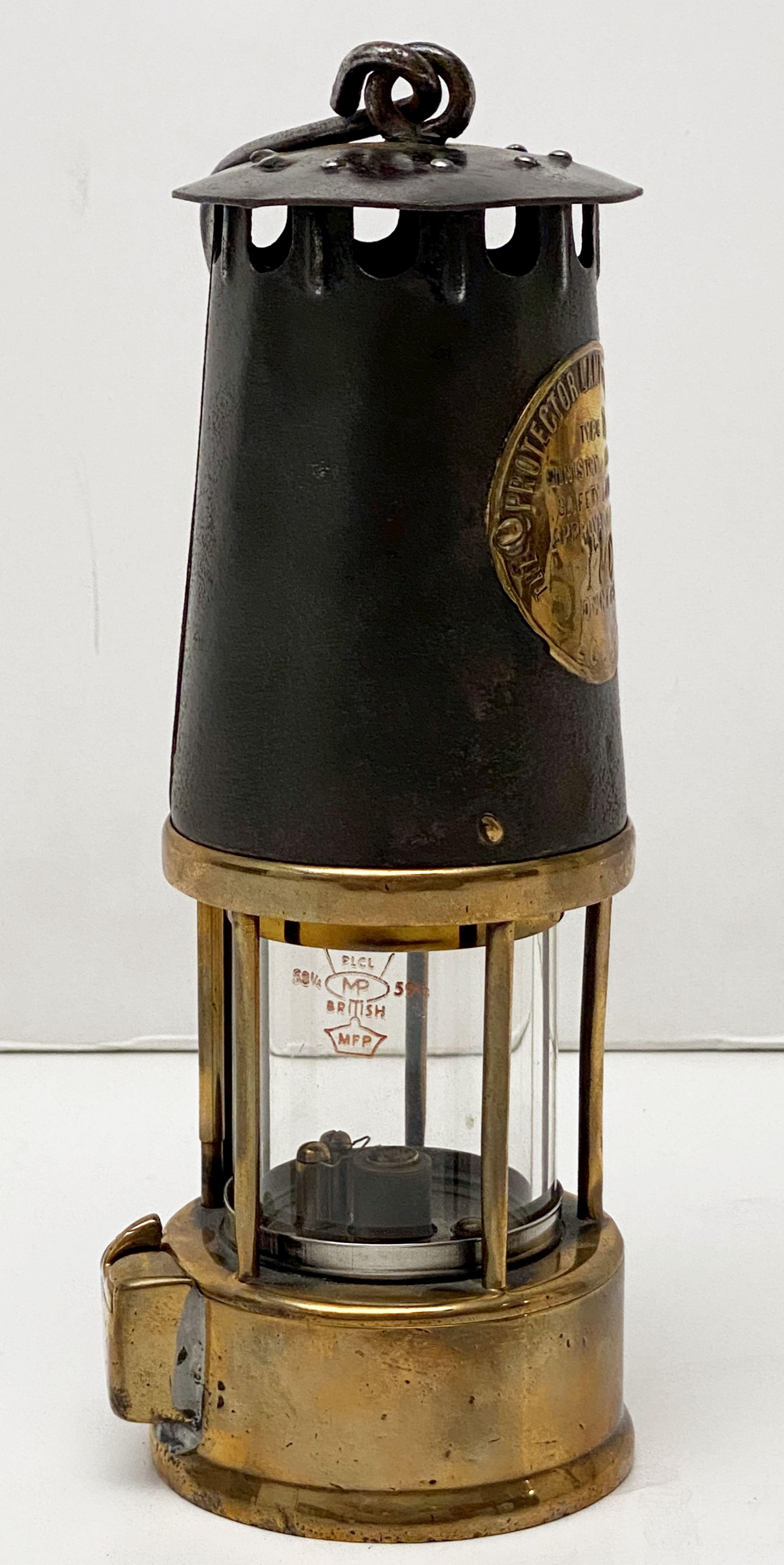 A fine vintage English miner's lamp or safety lantern of brass and steel in working order.
With maker's label - Inscription reads: 
The Protector Lamp & Lighting Co. Ltd, Type SL, Ministry of Power, Safety Lamps, Approval No B/120, Owners,