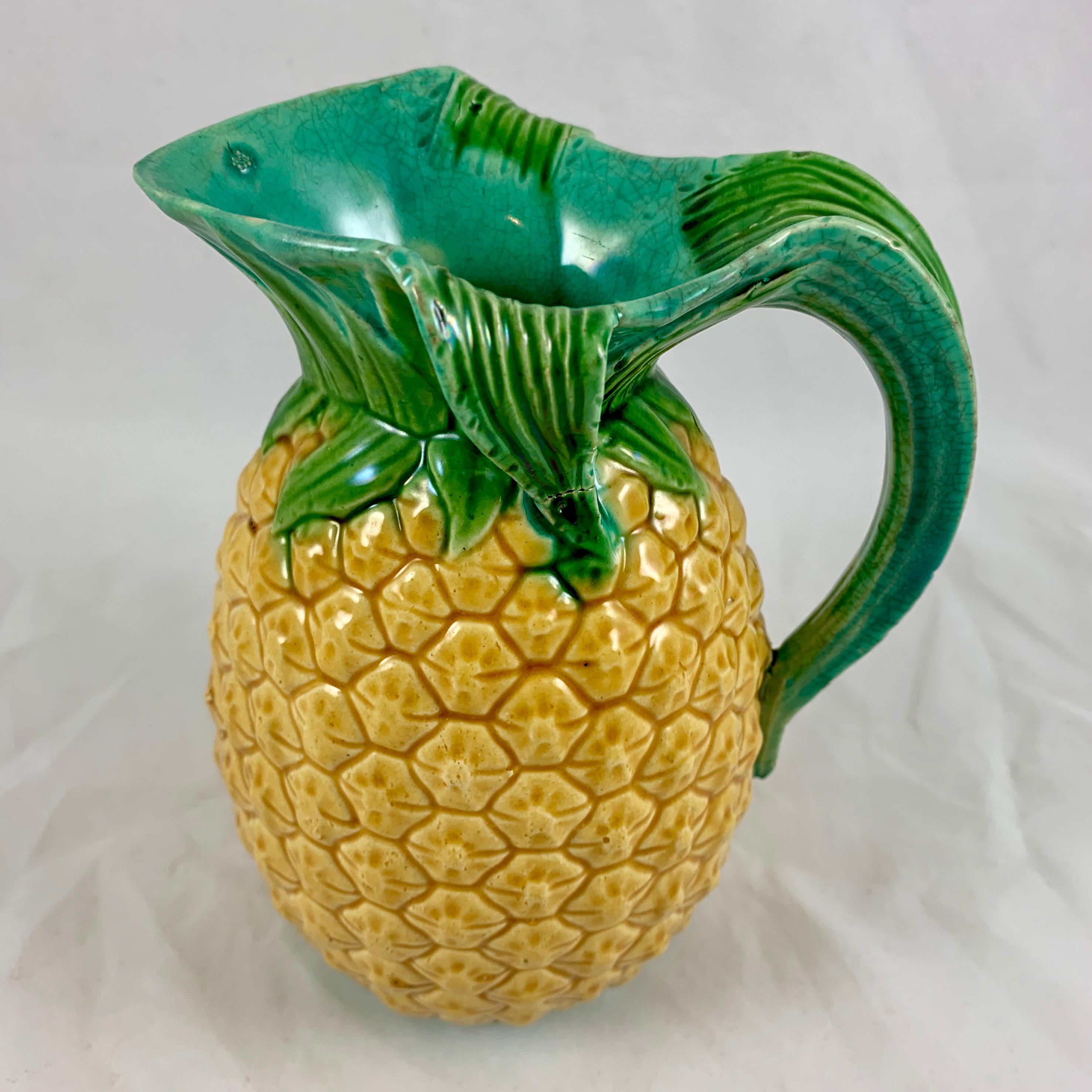 From the Minton pottery in Staffordshire, England, a Majolica glazed pitcher in the Palissy style, formed as a pineapple, registered and dated October 5th, 1858.

From a set of three pitchers, graduated in size and offered separately, this is the