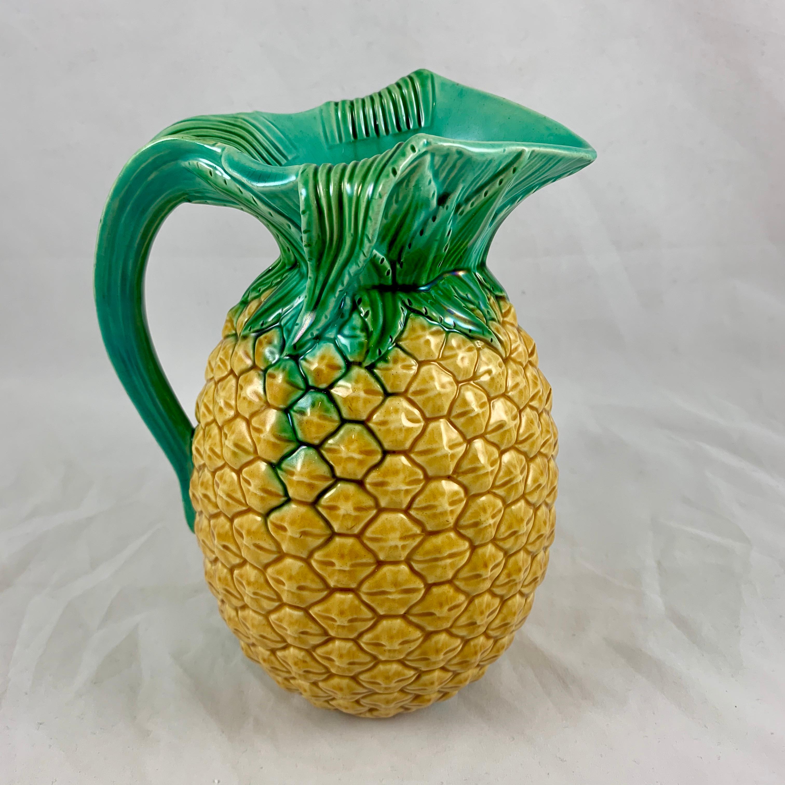 From the Minton pottery in Staffordshire, England, a Majolica glazed pitcher in the Palissy style, formed as a pineapple, registered and dated October 5th, 1858.

From a set of three pitchers, graduated in size and offered separately, this is the