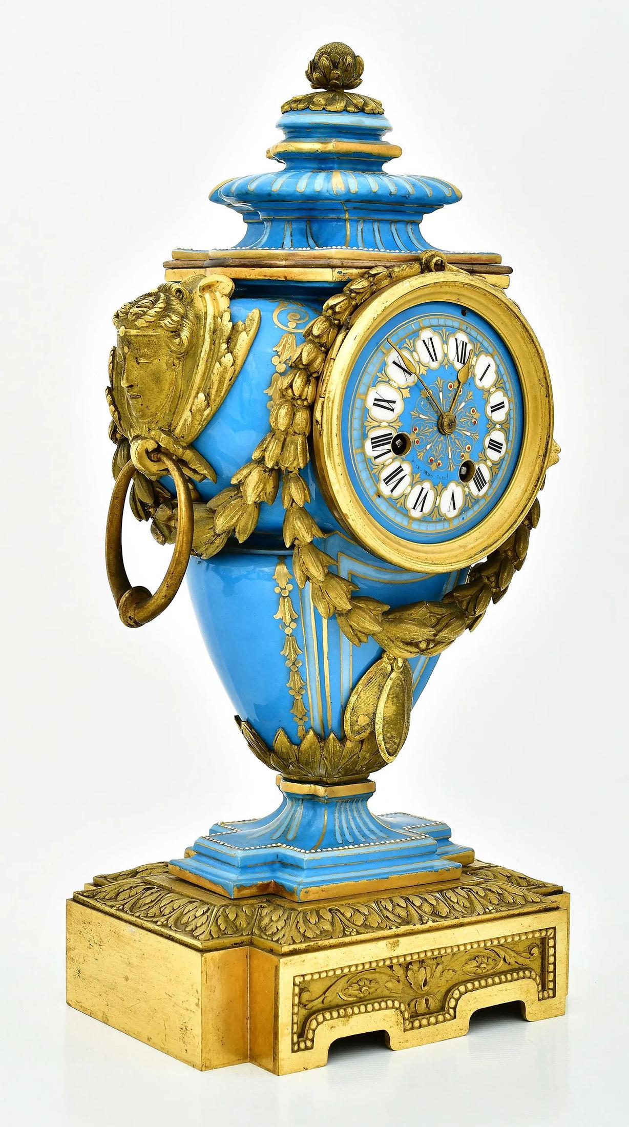 A Fine English Minton Bleu Céleste porcelain ground clock set consisting of a urn clock and two candlesticks with gilt bronze mounts of female mascrons and garlands, hand painted gold accents and red & white enamel jeweling. 

Origin: England
Date: