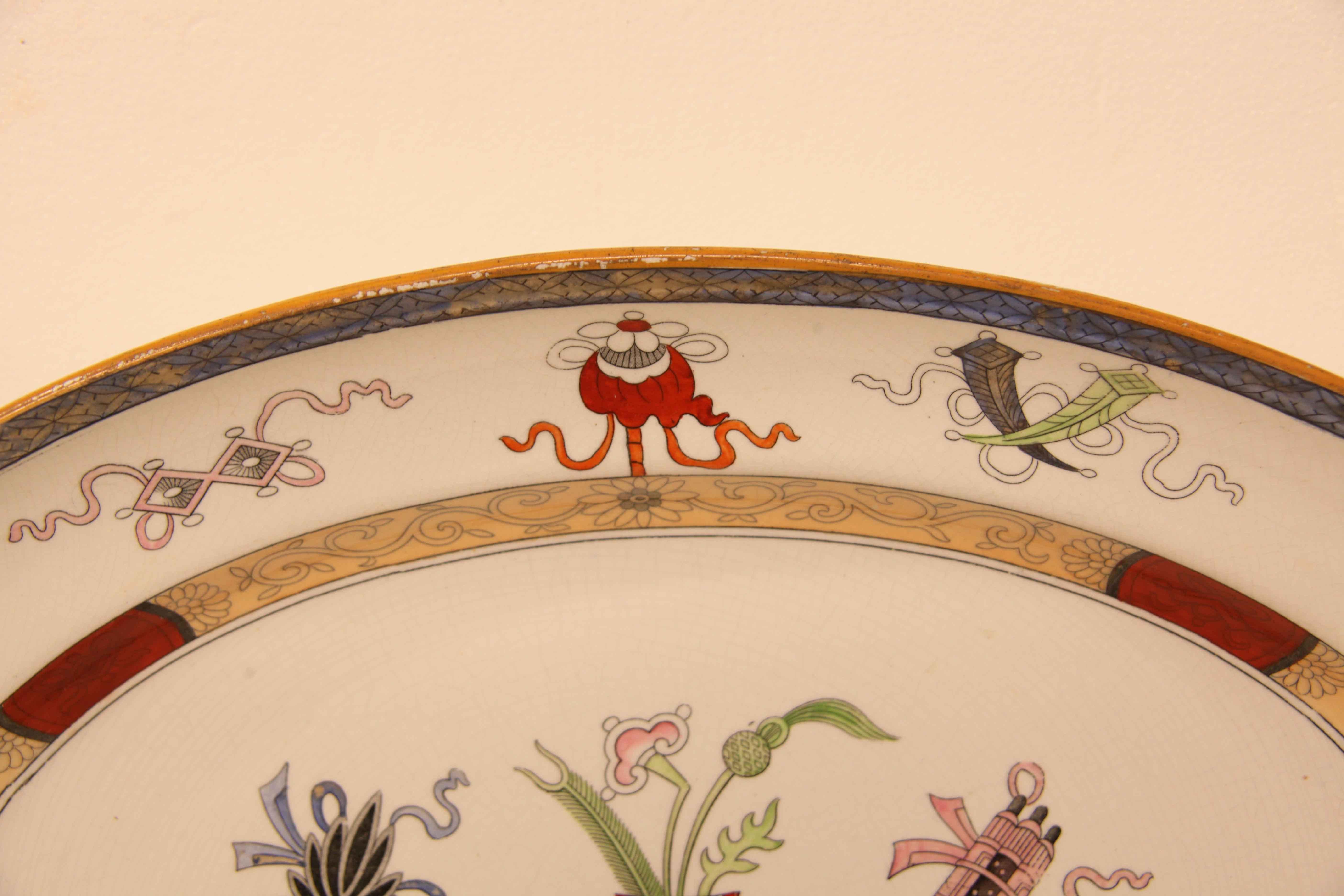 English Staffordshire platter, the rim has stylized flowers on a light blue background; the border features whimsical figures ( scrolls, flowers, etc) , this is followed by the slanted inner edge with flowers and arabesques on a salmon colored