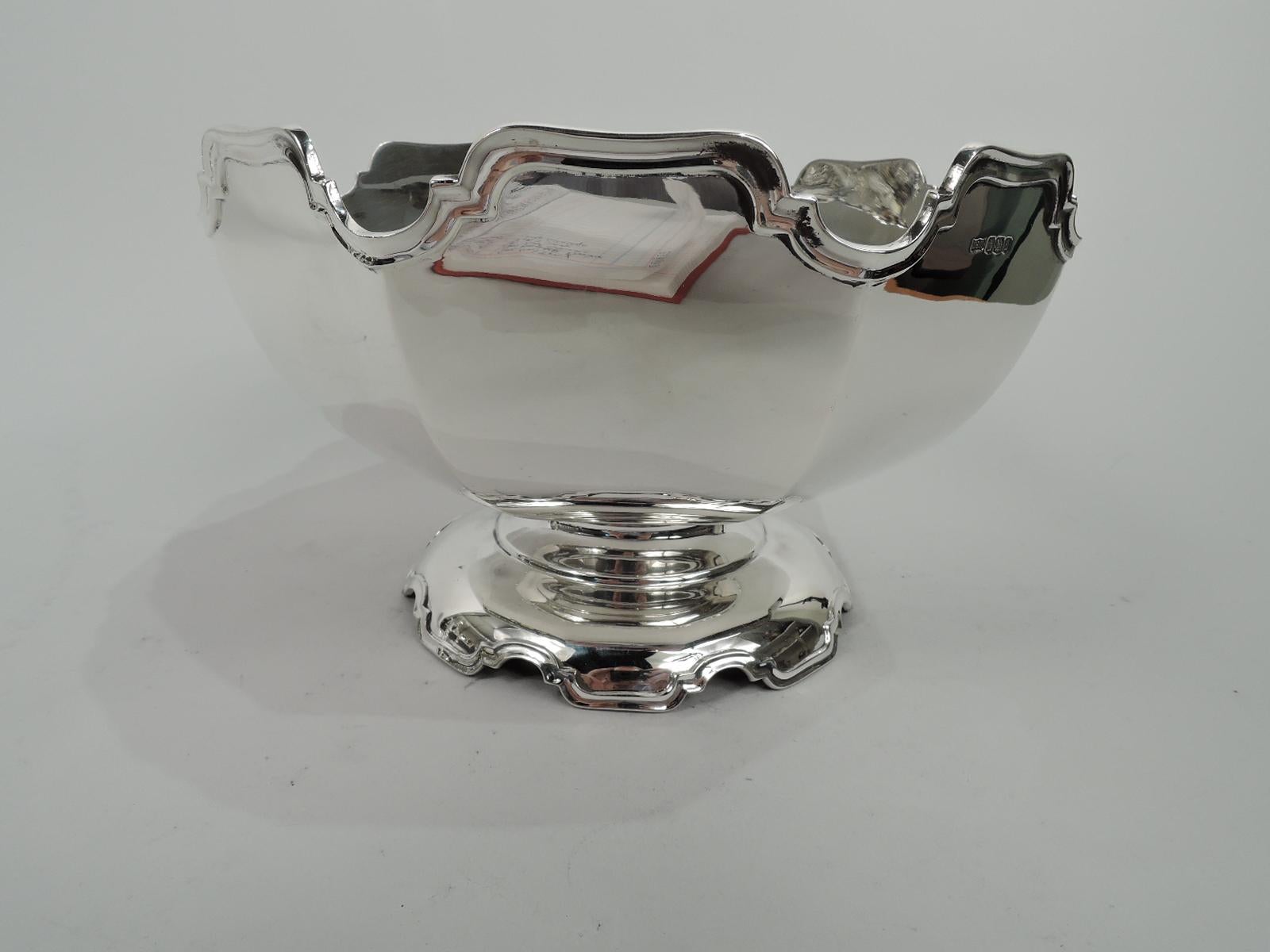 George V sterling silver bowl. Made by Mappin & Webb in Sheffield in 1923. Faceted and curved with monteith-style molded curvilinear rim. Foot raised with same. Fully marked including design no. 606564, which was registered in 1912. Weight: 21.8