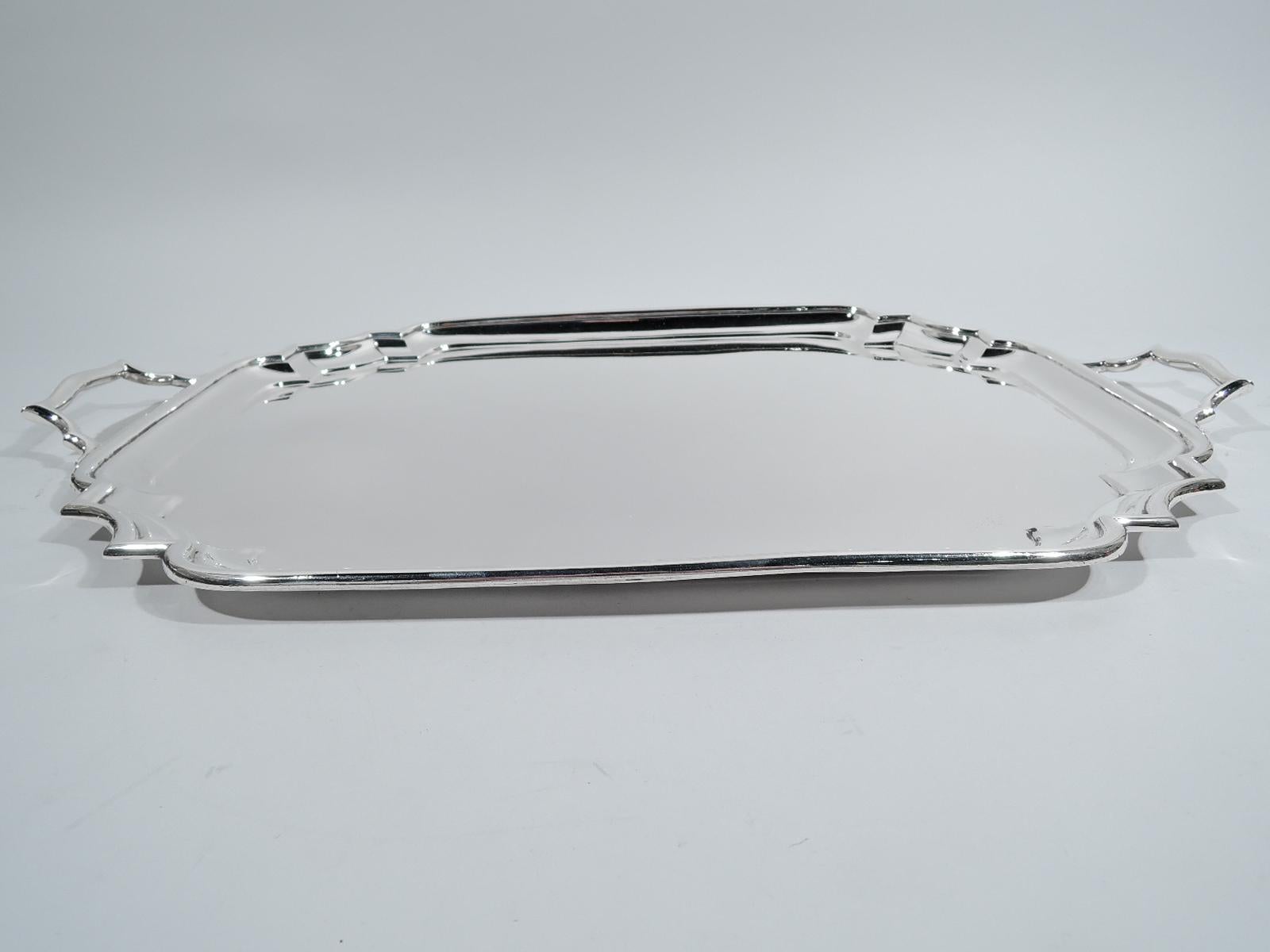 George V sterling silver tray. Made by Goldsmiths & Silversmiths Co. Ltd in London in 1922. Molded rim and curvilinear corners. Scroll bracket end handles. Ever popular Georgian brought up to date for the Jazz Age. Intended for serving tea but works