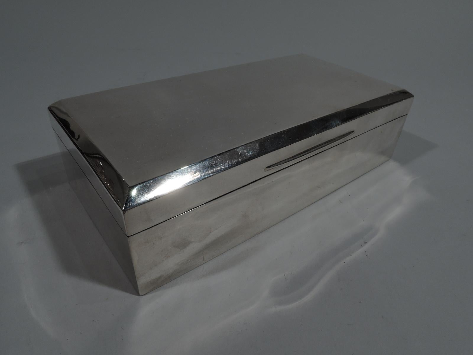 George V sterling silver box. Made by Mappin & Webb in London in 1926. Rectangular with straight sides. Cover hinged, flat, and chamfered with tapering tab. Box and cover interior cedar-lined with detachable partitions. Box underside leather lined.