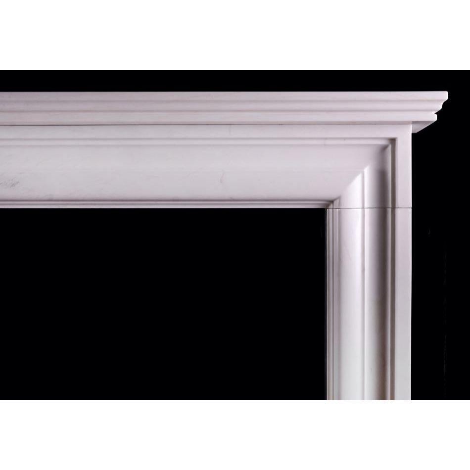 An English moulded bolection fireplace in white marble. A scaled down version of a chimneypiece originally housed in the Officer's mess at Chelsea Barracks, London. Can be made to any size, in various materials. N.B. May be subject to an extended