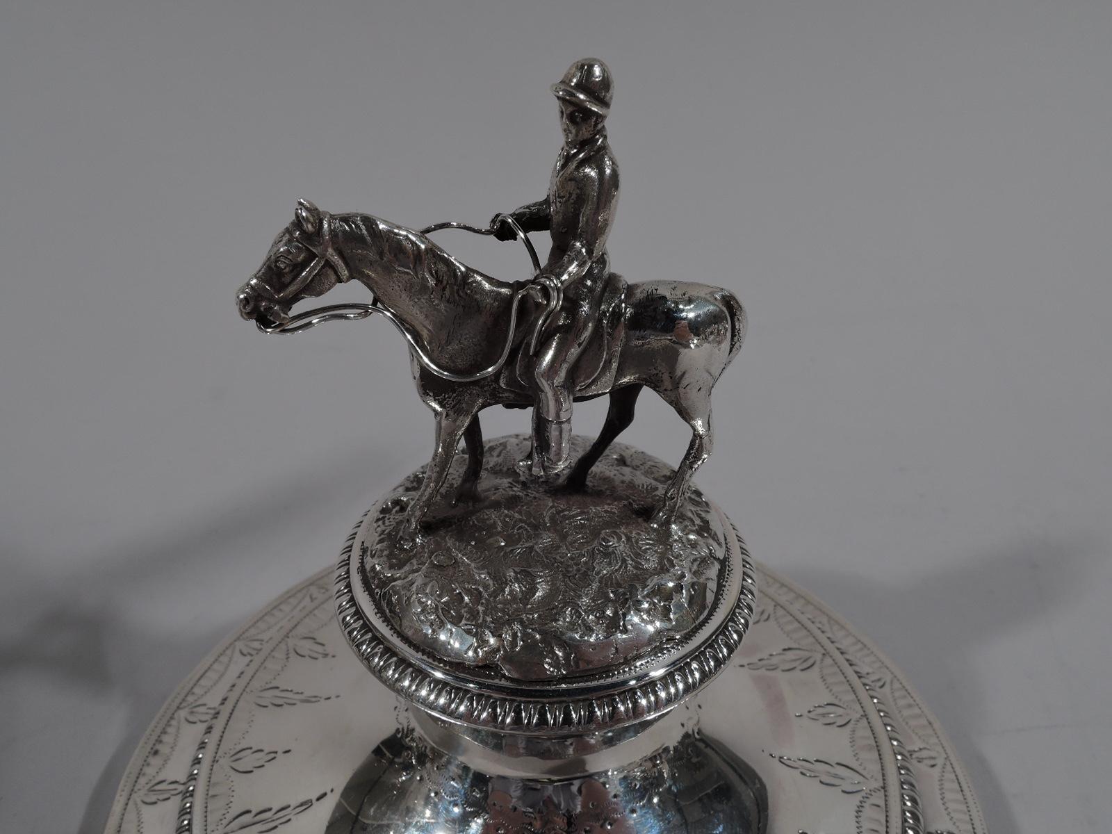 George III sterling silver covered urn. Made by William Frisbee in London in 1805. Ovoid with half fluting and split-leaf mounted scroll-bracket side handles. Short spool support and stepped foot. Domed-spool cover with cast figure of mounted