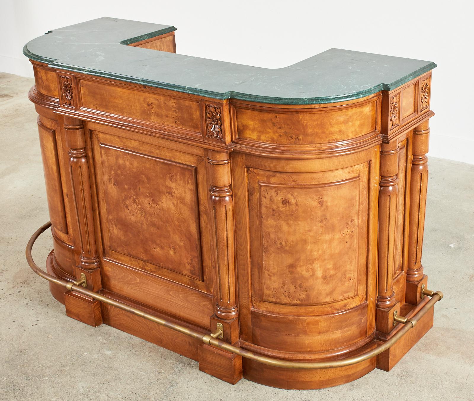 Opulent English carved dry bar featuring two conforming dark green marble tops. The large case is constructed from walnut, mahogany, and radiant burlwood veneer inlay having a demi-lune form. Crafted with pilaster columns and carved rosettes in the