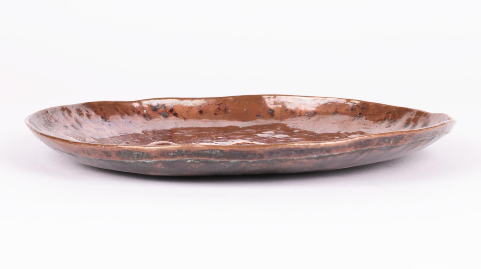 Une plaque ou un plat en cuivre battu très élégant de style Arts & Crafts anglais avec un héron attribué au célèbre atelier de Cornouailles Newlyn et datant d'environ 1900. Le plat est fabriqué à la main dans un cuivre épais. Le héron, unijambiste