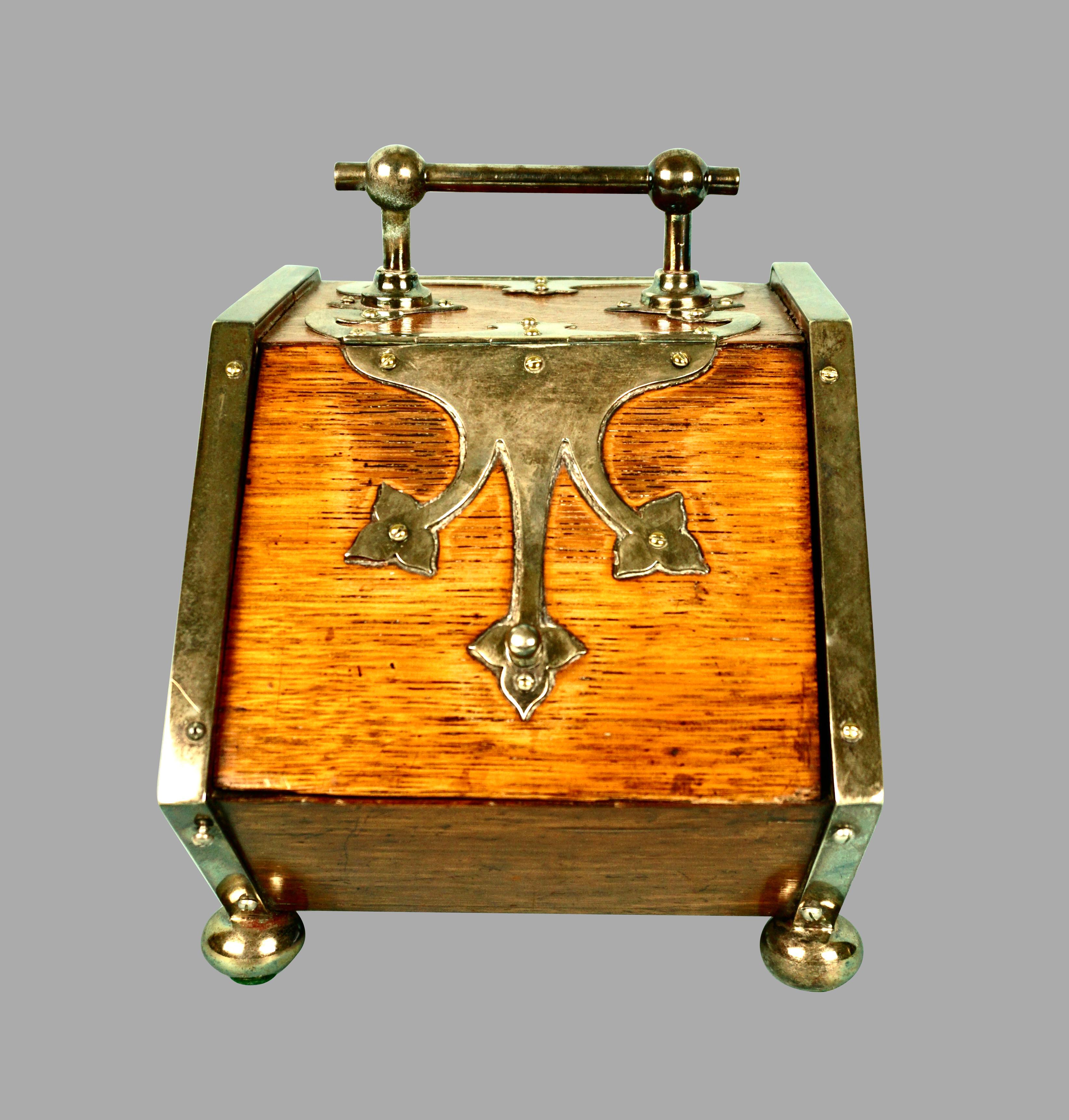 A very unusual English oak and silver plate biscuit server in the form of a coal scuttle. This piece is reminiscent of a patent model and is extremely well detailed.
It opens on both ends and is fully functional. A rare and charming piece of English