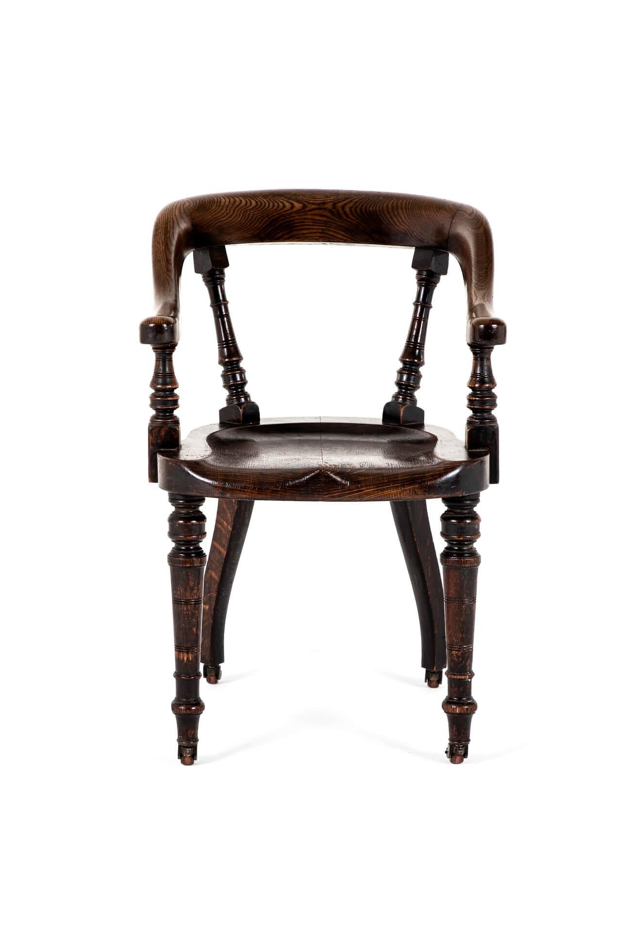 Chaise de bureau en chêne de la fin de l'époque victorienne, avec un dossier à quatre piliers tournés.

La chaise est complétée par une assise profonde et large sur quatre pieds tournés et terminée par des roulettes d'origine.

Une chaise très