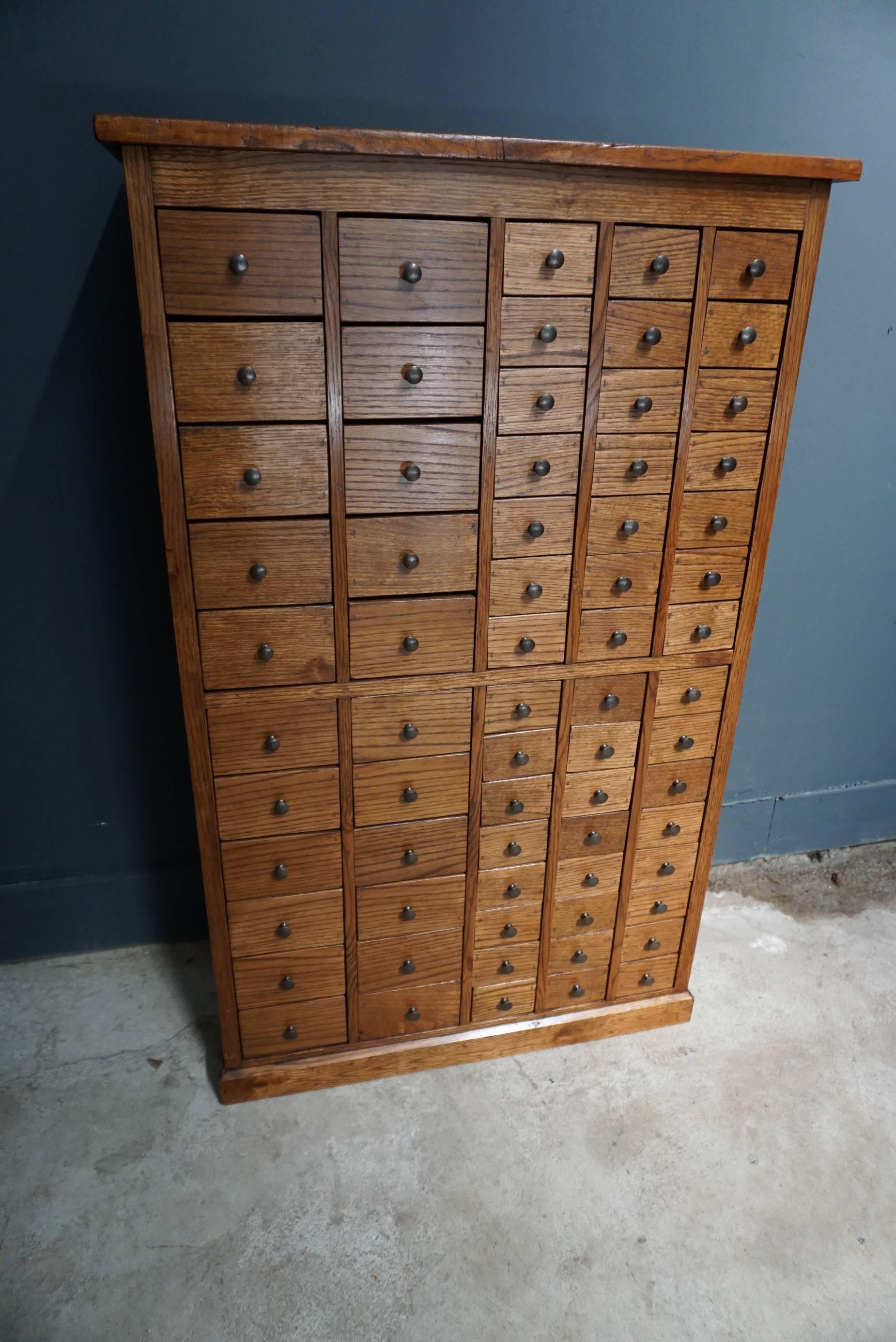 This oak apothecary cabinet was designed and made, circa 1900 in England. It features 67 drawers with brass hardware. The inside of the large drawers measure: 26.5 x 12.5 x 8.5 cm and the small drawers: 26.5 x 7.8 x 5.6 cm.