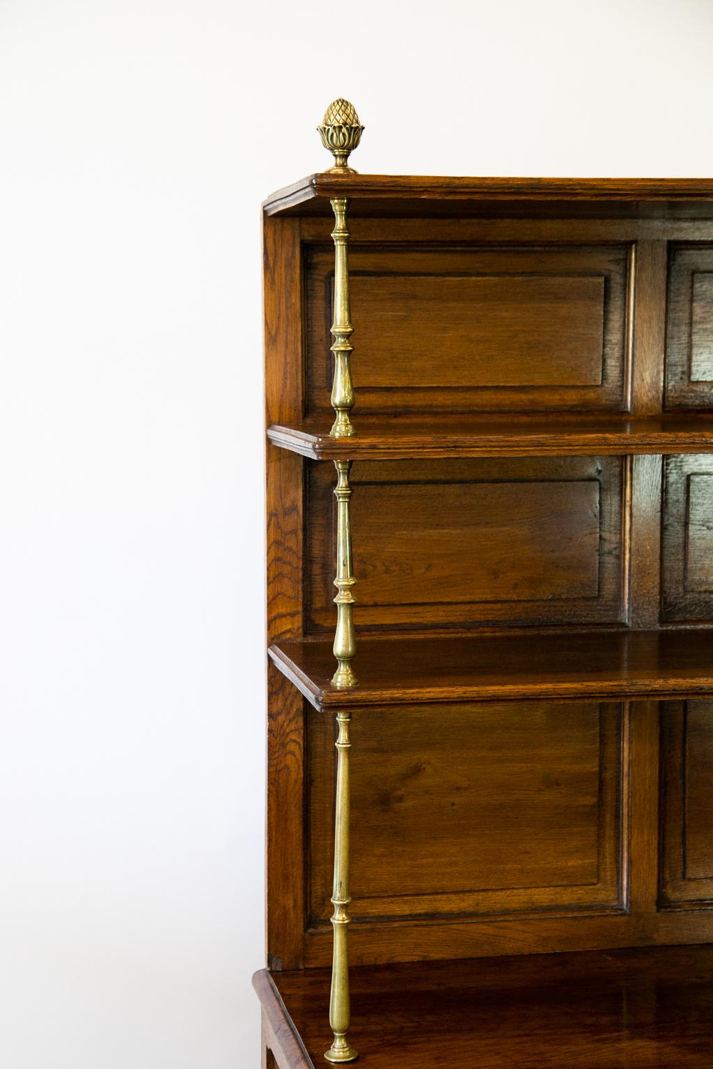 English oak bar server, with the upper half having three shelves supported by turned brass shelf supports with pineapple finials. The top section is removable from the bottom which has two pull out slide compartments with four divisions in each