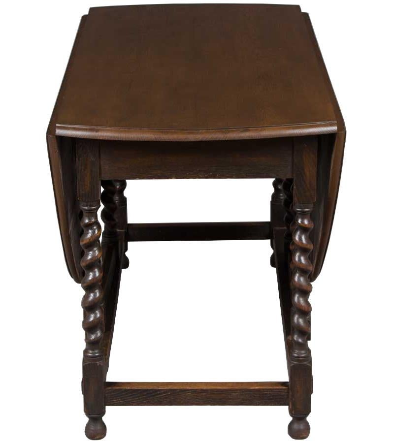 This classic style, English oak barley twist gate leg drop leaf table was made around the year 1920. It's a larger gate leg that would serve well as a sofa table when closed and makes a decent sized table when opened. With the leaves down the top