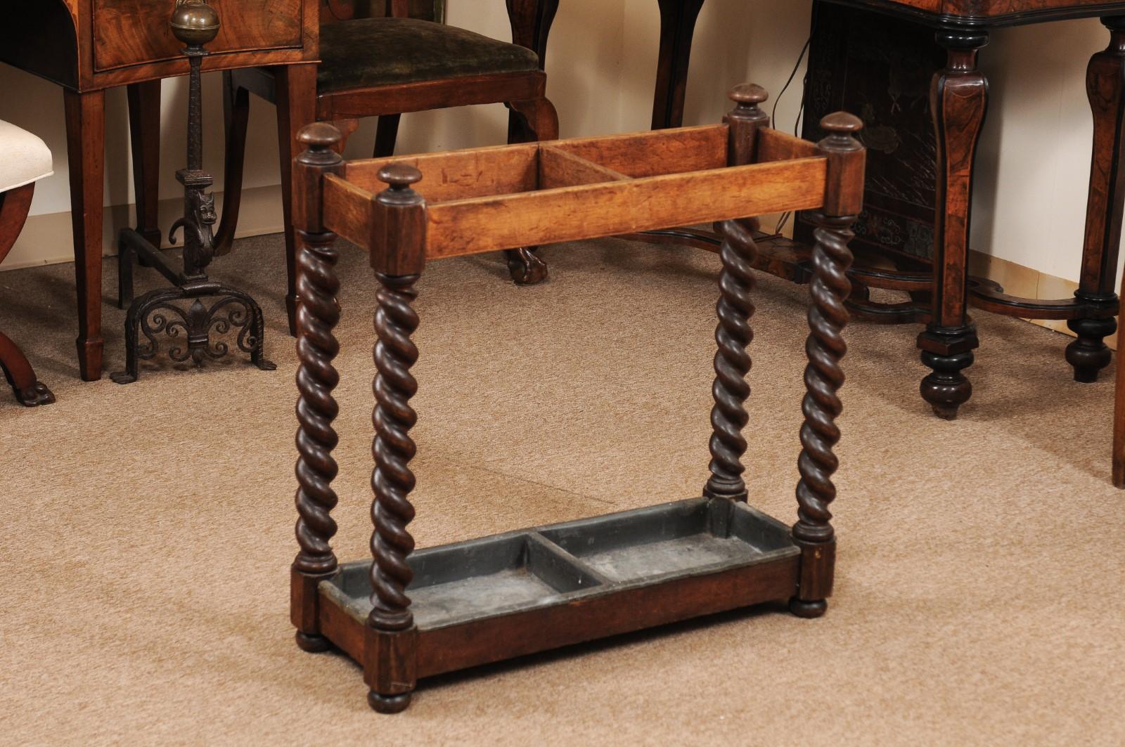The late 19th century English oak umbrella stand with barley twist detail and bun feet.