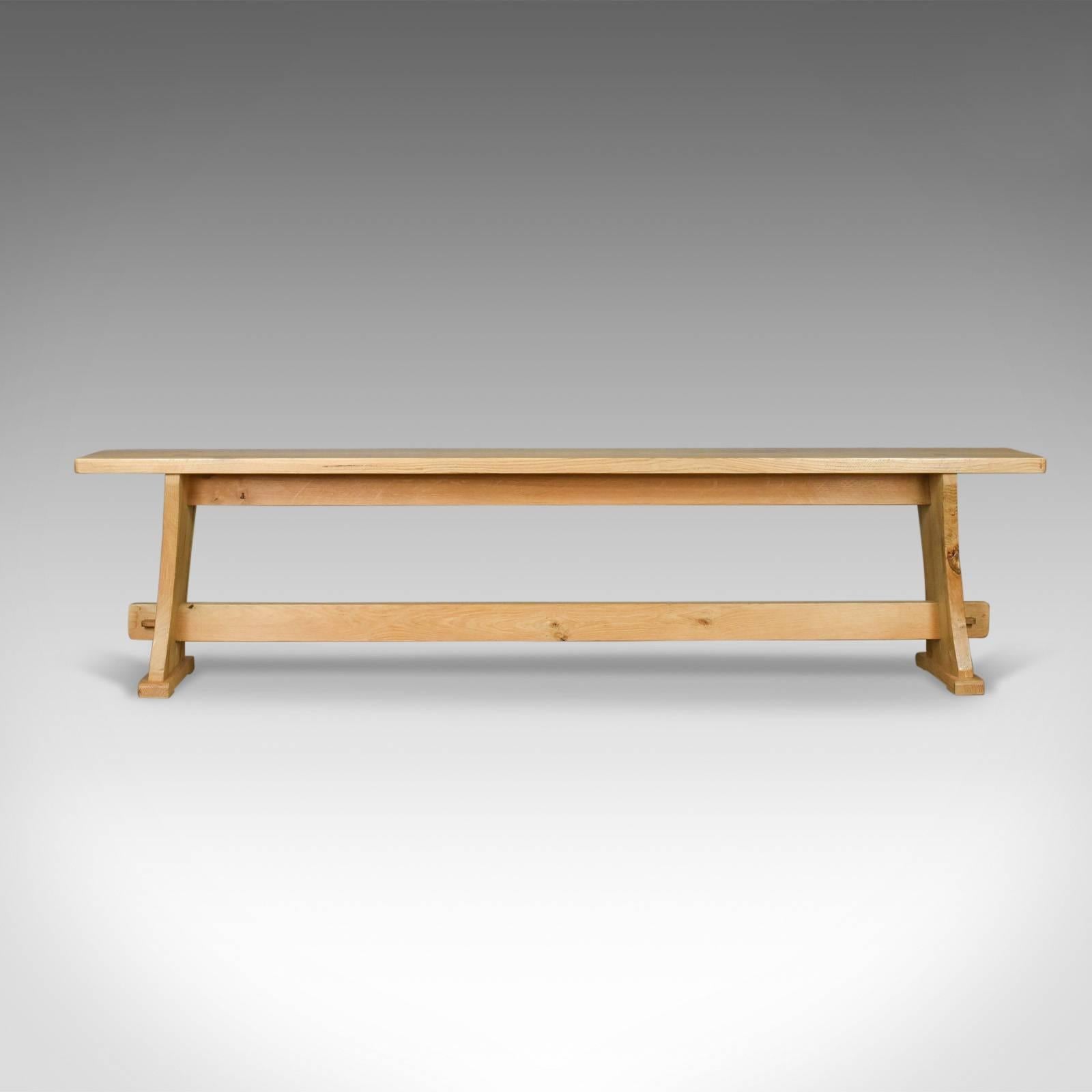 This is an English oak bench in the Victorian taste, a long, four-seat kitchen form dating to the late 20th century.

Substantial, solid, heavy English oak
Displaying good light color with grain interest
Traditionally crafted with through