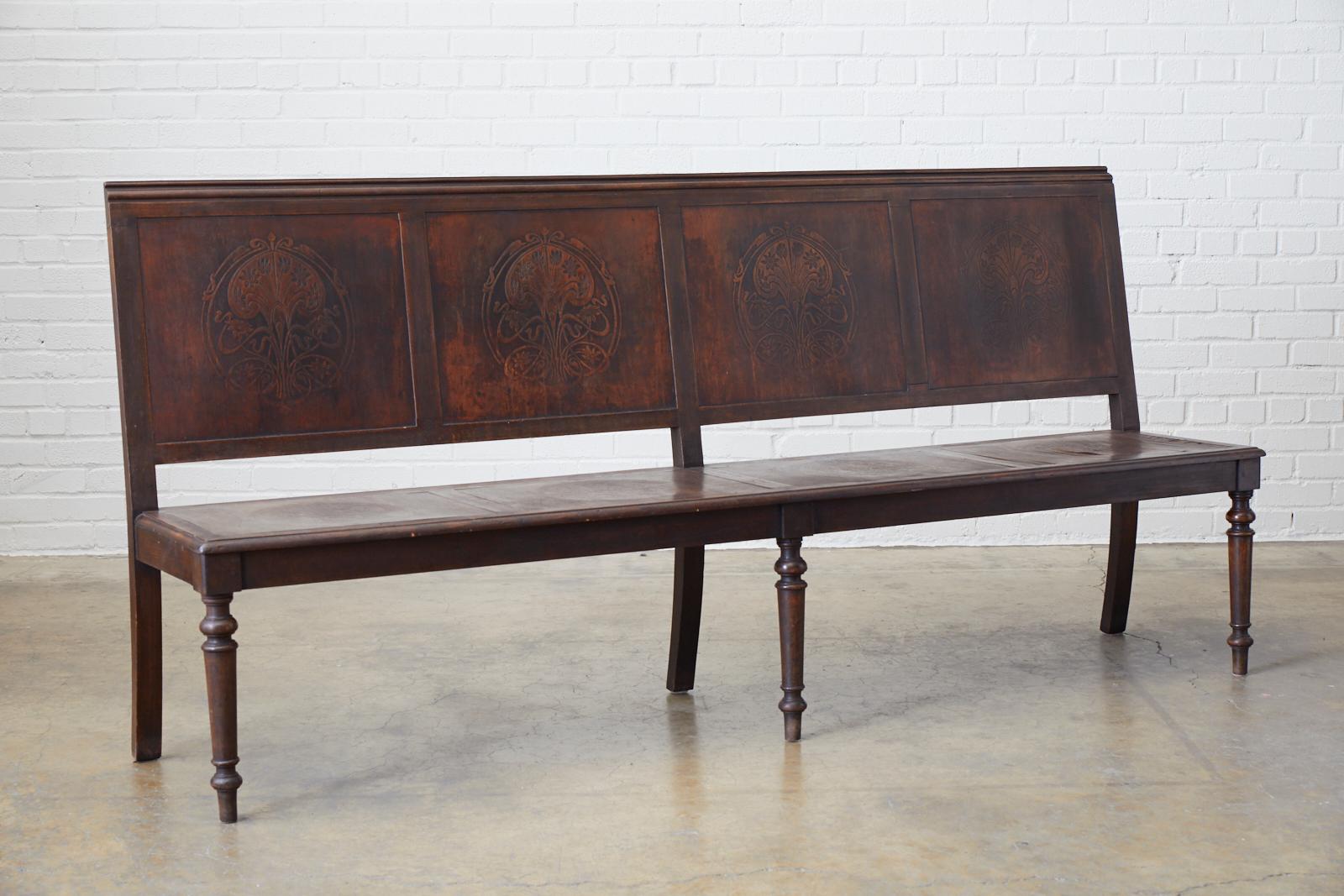 Unique late 19th century English oak bench or settle from the late Victorian period featuring Art Nouveau embossed panels. This unique bench is a transitional piece as it has been decorated with early Art Nouveau designs of stylized flora motifs on