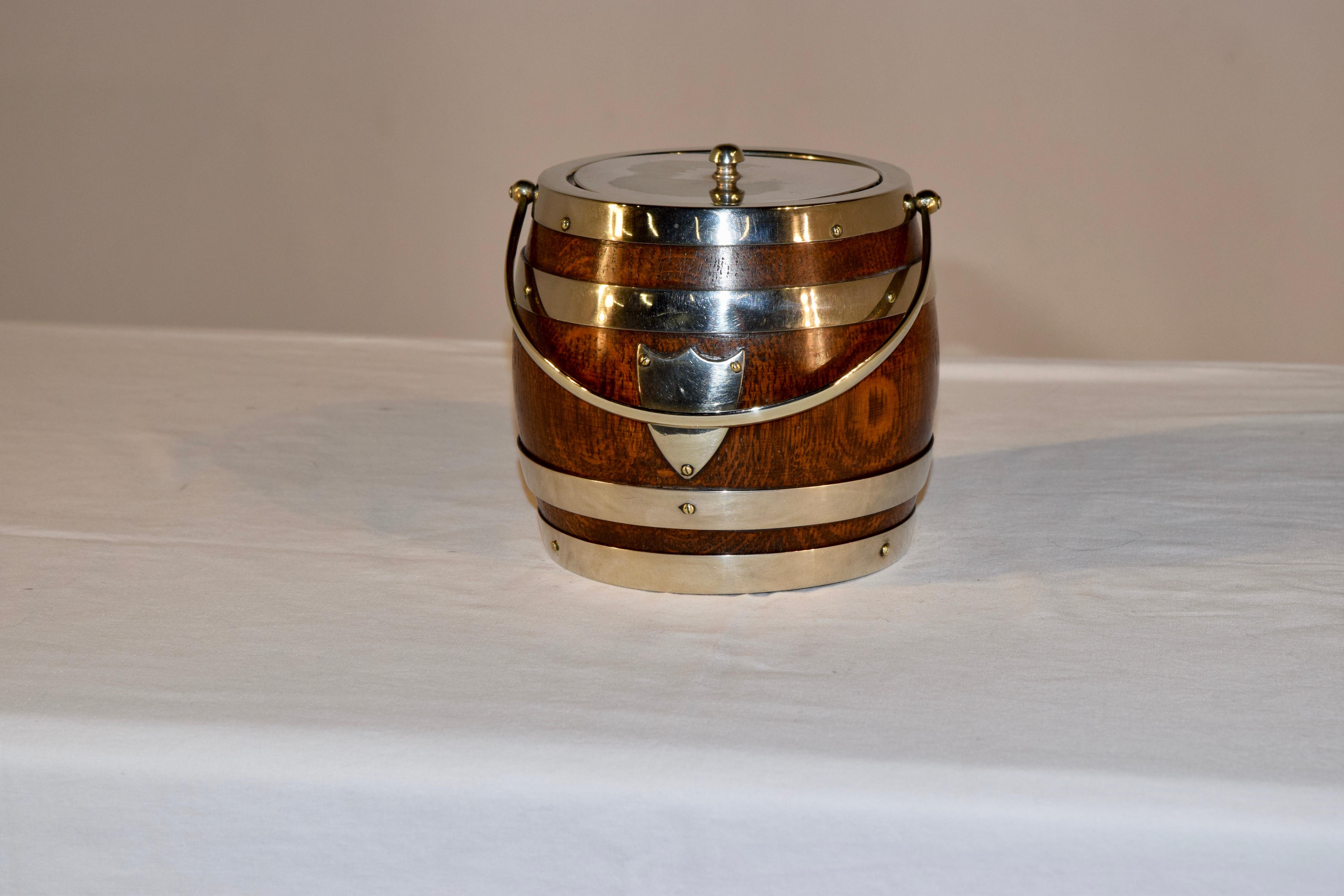 English oak biscuit barrel with silver plated lid and banding. It retains the original porcelain liner inside.
 