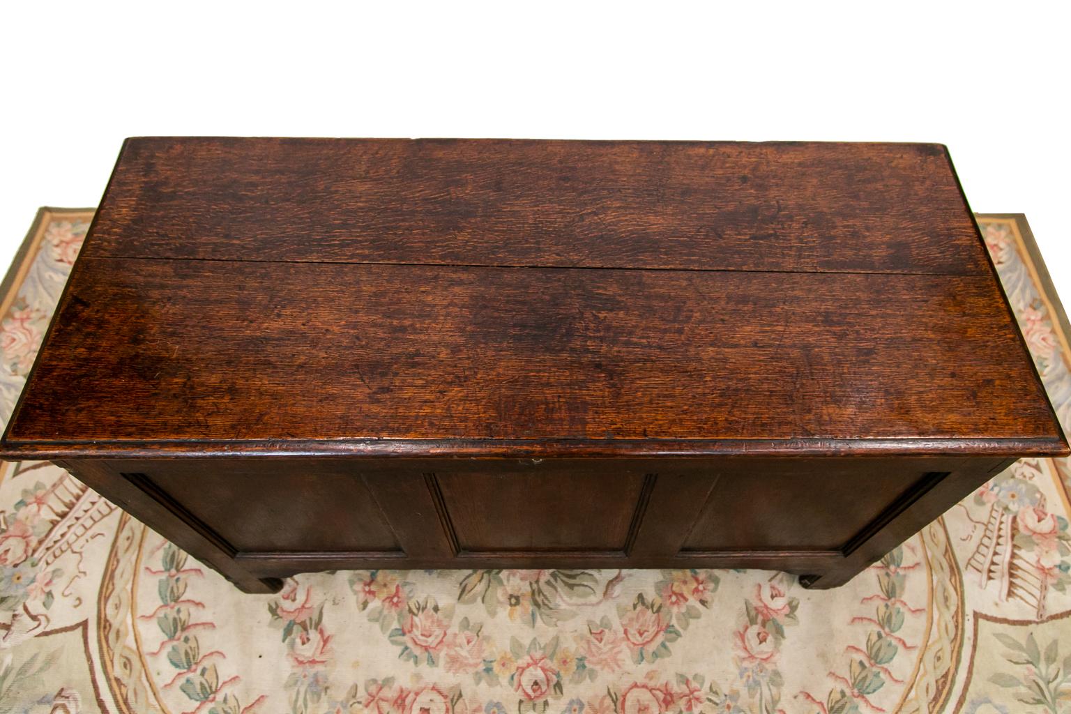 This blanket chest has the original steel rat tail hinges, lock and key, and escutcheon. The front has three recessed panels framed by shaped moldings. The sides have singles recessed panels framed by carved moldings on the top and bottom. The top