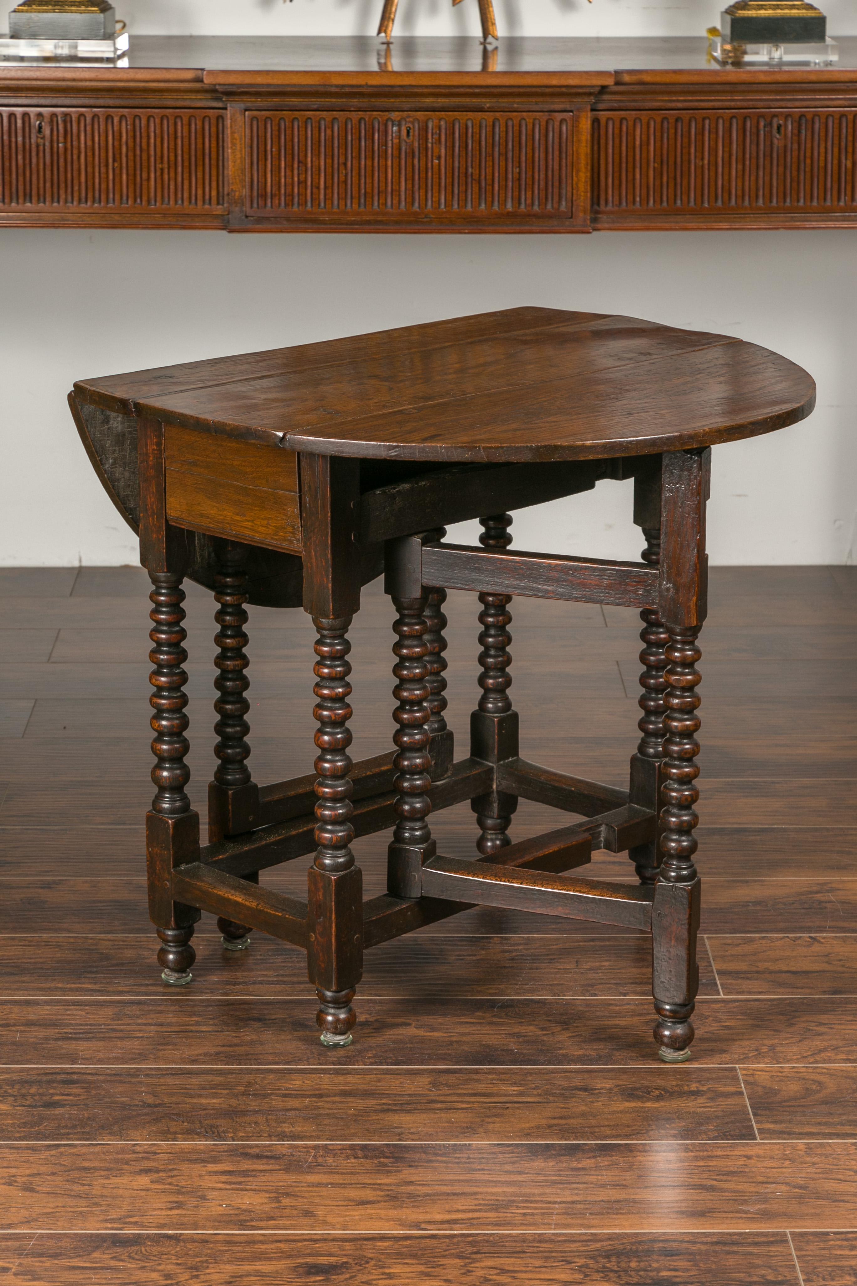 19th Century English Oak Bobbin Leg Drop-Leaf Oval Table with Single Drawer and Stretchers