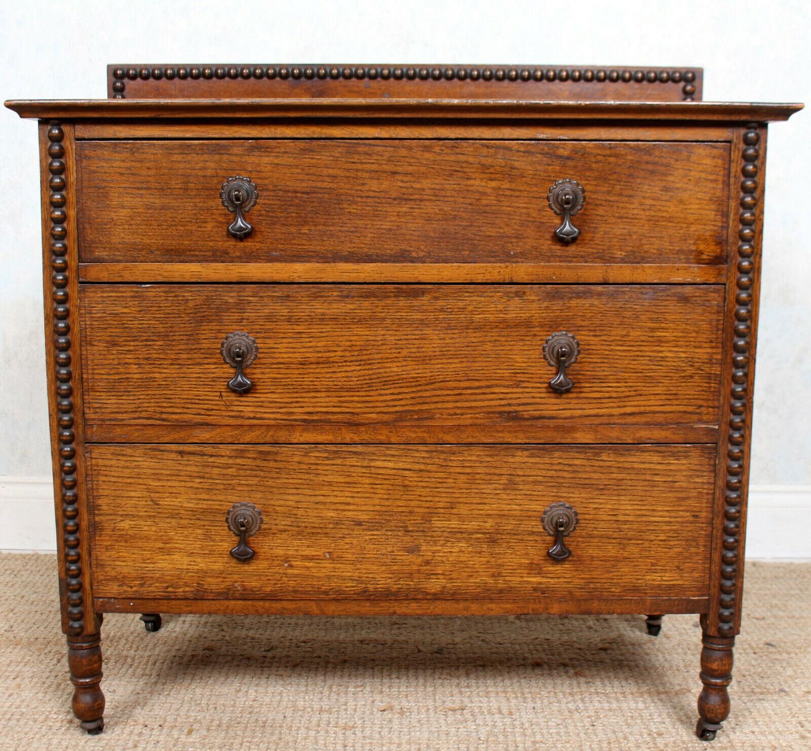 An impressive Arts & Crafts oak chest of drawers.

The oak boasting a well figured wild golden swirling and flecked grain and rich patina.

The backrail with decorative beaded borders. Fitted three long graduated drawers - flanked by matched