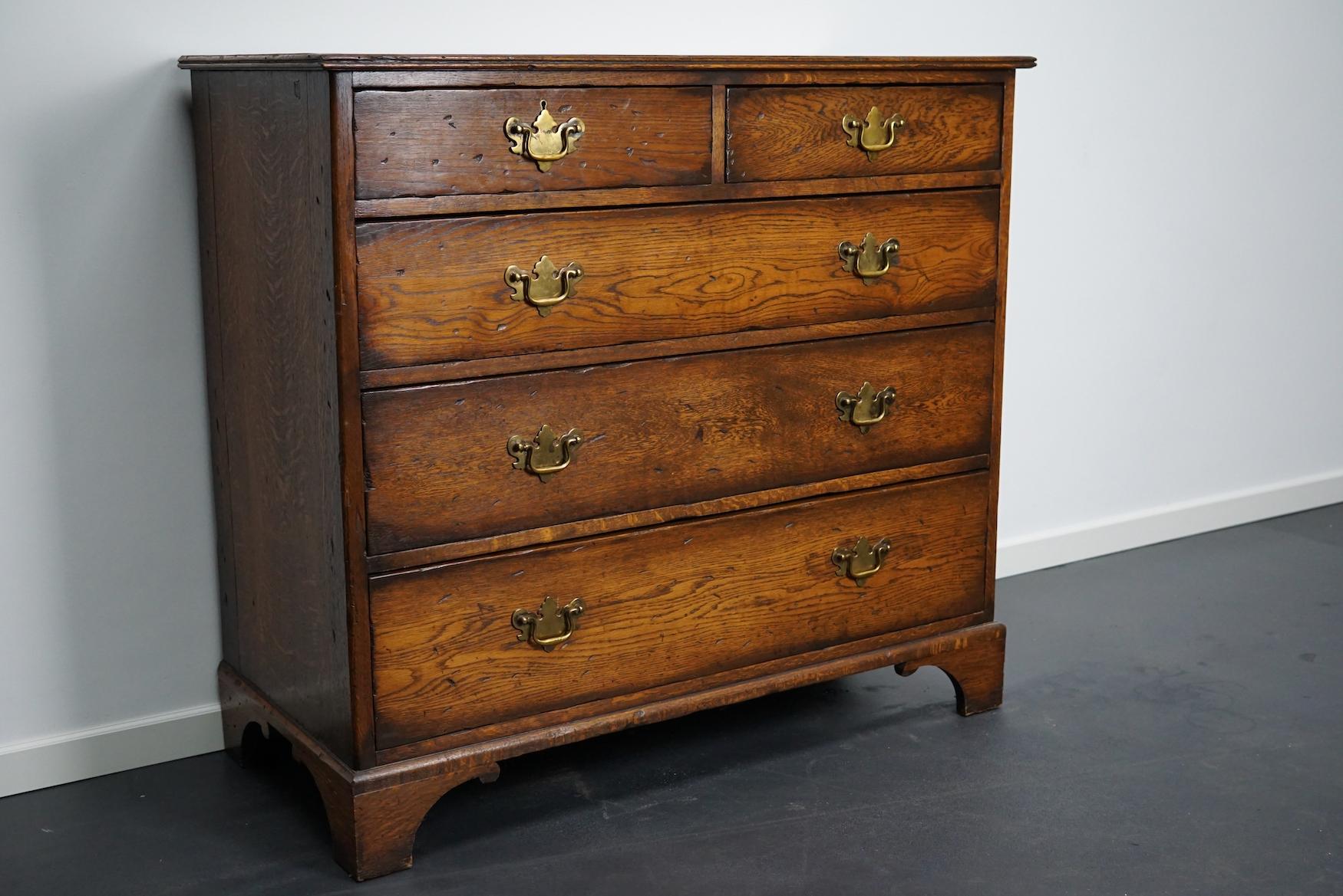 Very nice solid oak chest of drawers made circa early 20th century in England in Georgian style. It features 5 drawers with an original lock (no keys). It remains in a good condition with a nice patina and color. The interior dimensions of the
