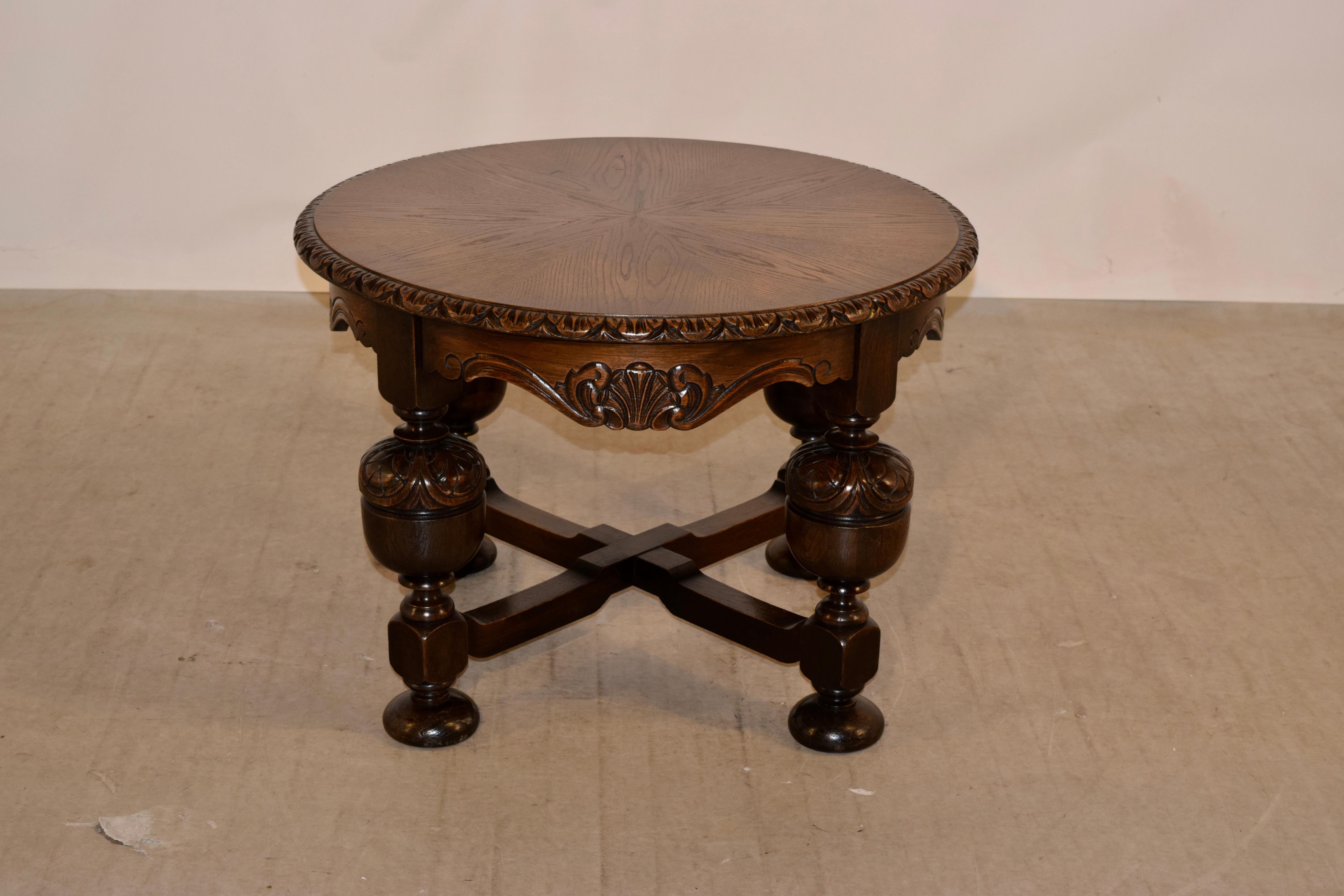English oak cocktail table, circa 1900 with a wonderfully parqueted top in a wheel pattern, all with a beveled and hand carved decorated edge over thickly hand turned and carved decorated legs, joined by shaped cross stretchers. Supported on hand