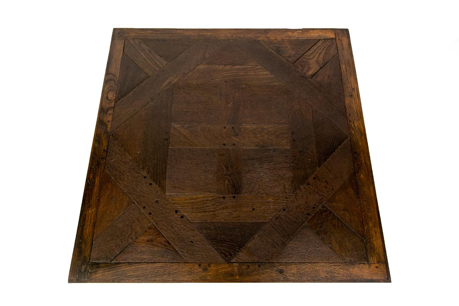 English oak coffee table is made from reclaimed antique flooring and has exposed double peg construction. The top is constructed with geometric patterns resting on four square legs.
