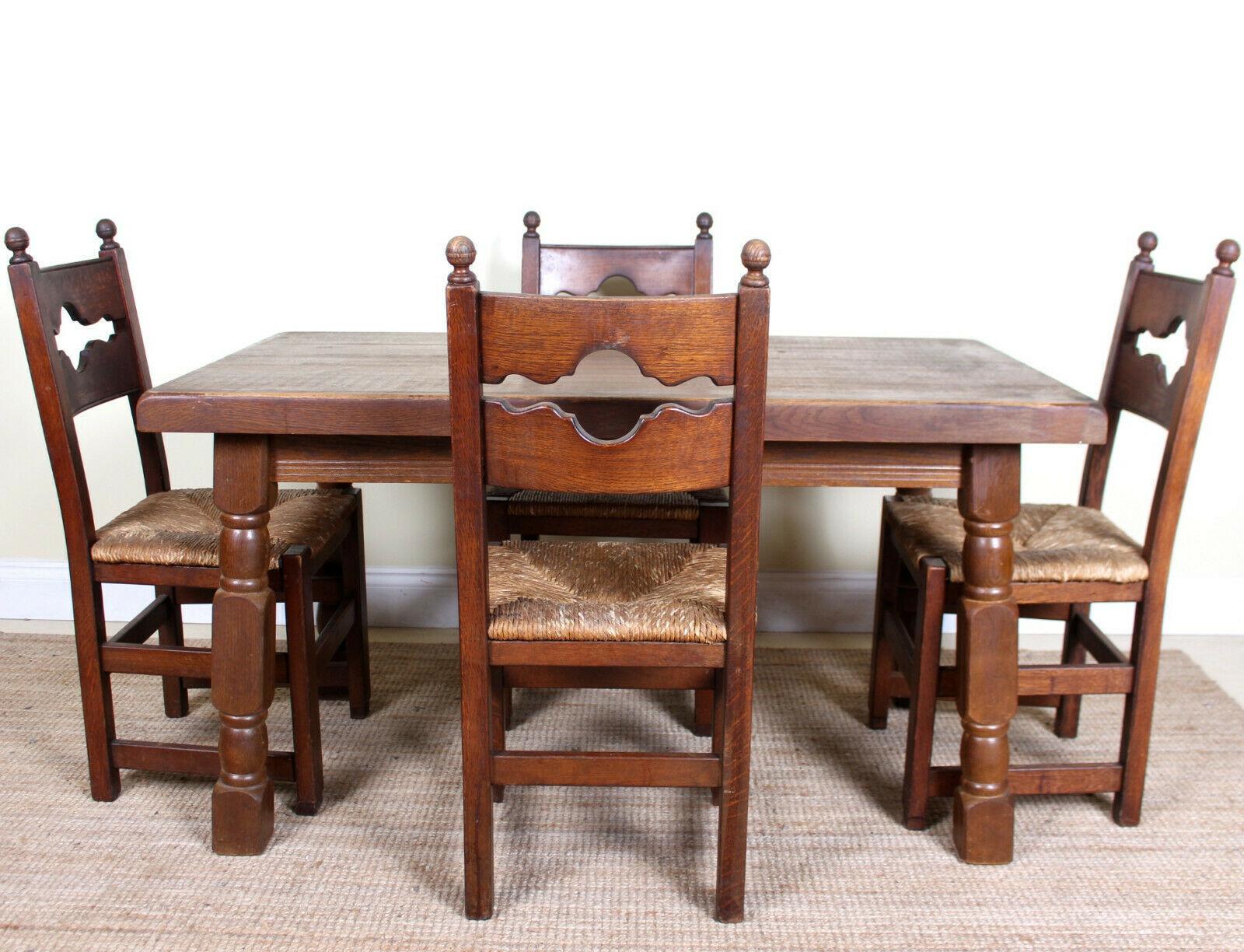 An impressive antique five-piece oak dining suite.
Constructed from thick cuts of oak boasting a well figured grain.
The chairs constructed from solid oak with rushwork seats.
The table legs can be unscrewed for ease of movement.