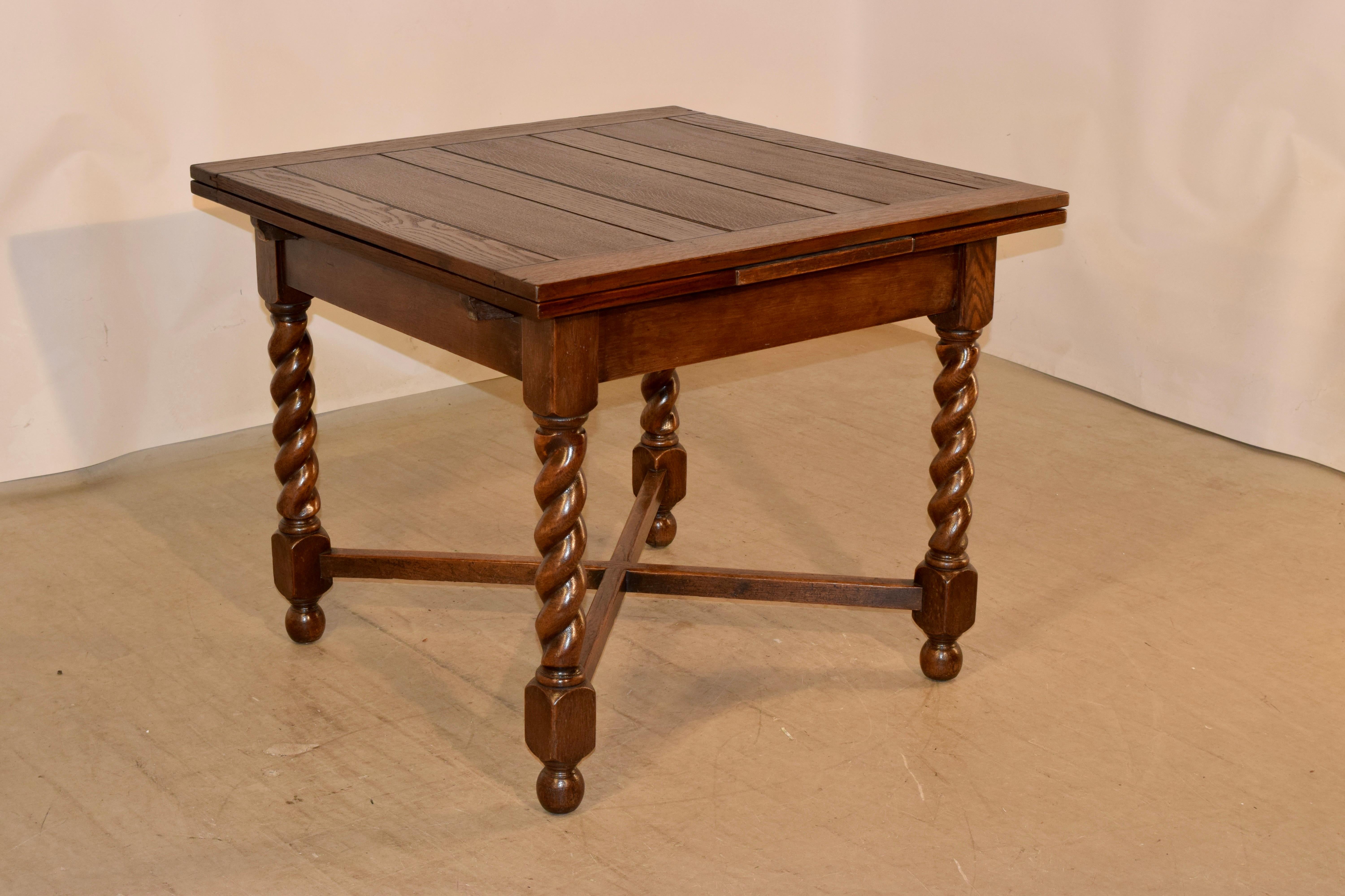 Circa 1900 oak draw-leaf table from England made from oak. The top is paneled, and has two leaves that pull out to extend the length of the table to 59.88 inches. The leaves are paneled as well. The apron is simple and is supported on hand turned