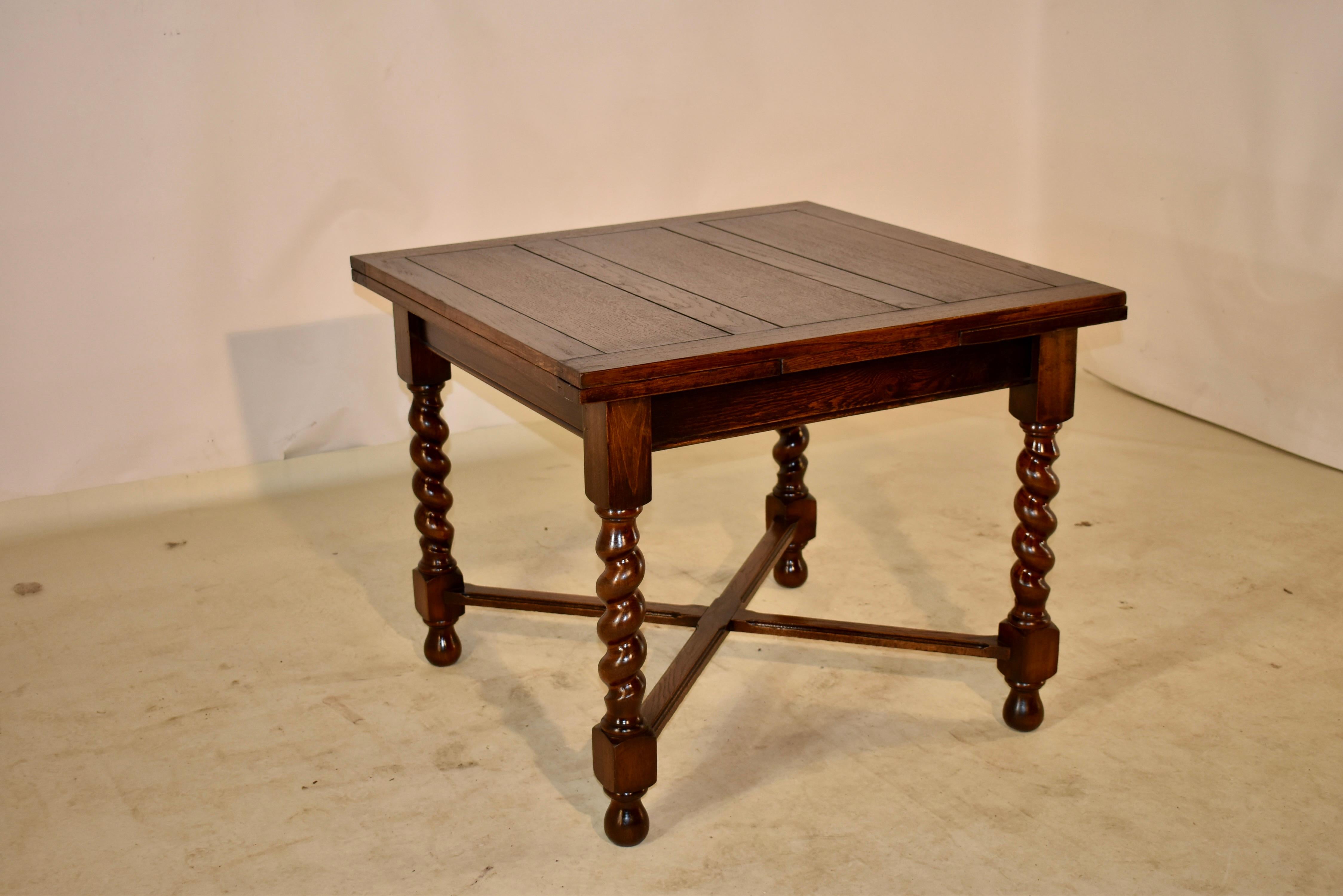 Edwardian oak pub table with draw leaves, c. 1900. The top and leaves are paneled and are supported on a simple apron following down to hand turned barley twist legs, joined by simple routed cross stretchers. The table is raised on hand turned feet.
