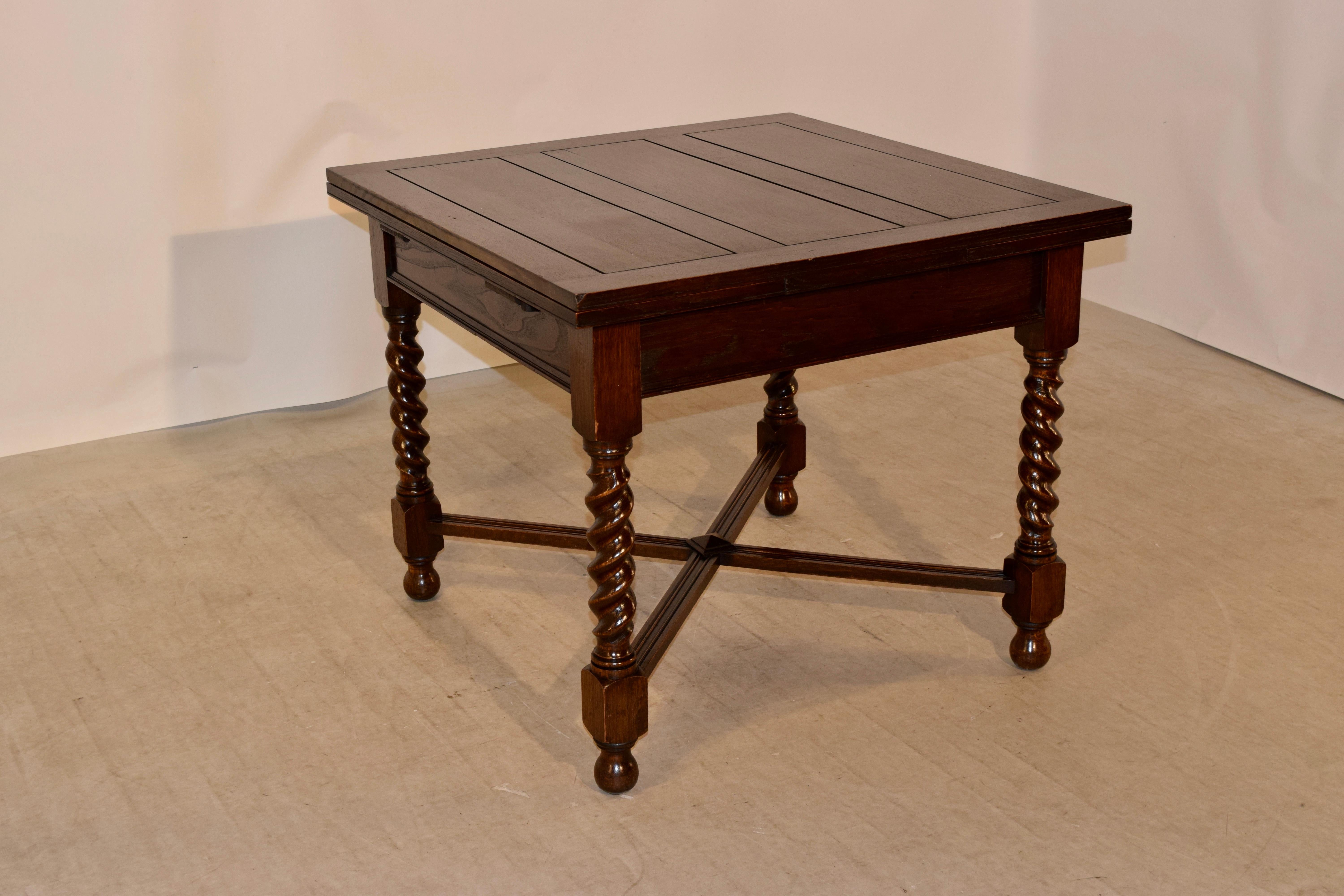 English oak table with draw-leaves made from oak. The top is paneled as well as the pull out / pull-out leaves, following down to a simpler apron with a molded edge and supported on thickly hand-turned barley twist legs, joined by cross stretchers,