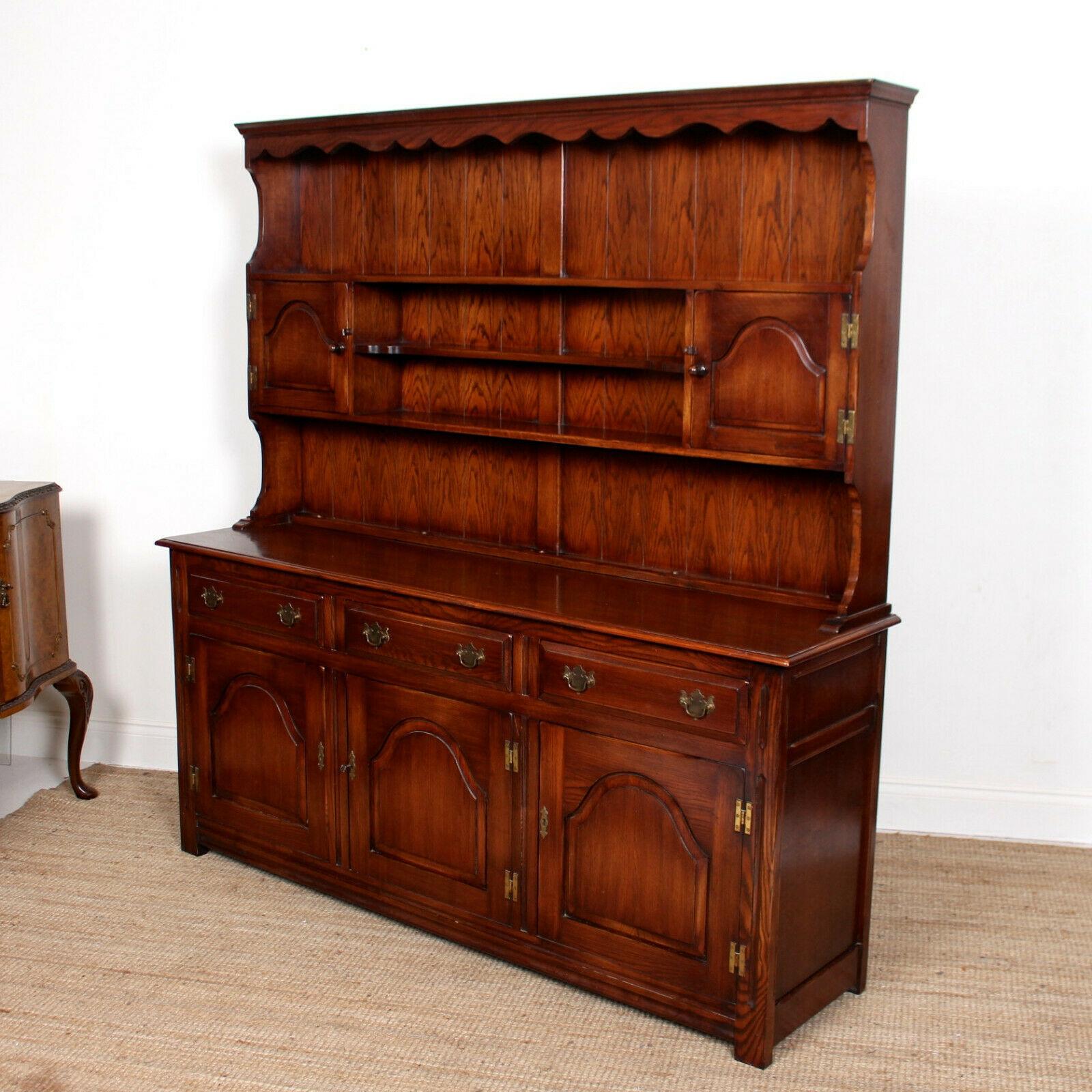 A fine quality oak dresser Bevan funnel.
The oak boasting a well figured grain and deep rich patina.
The upper section with carved apron to cornice above shelving and cupboards. The base fitted three drawers to frieze above carved paneled doors