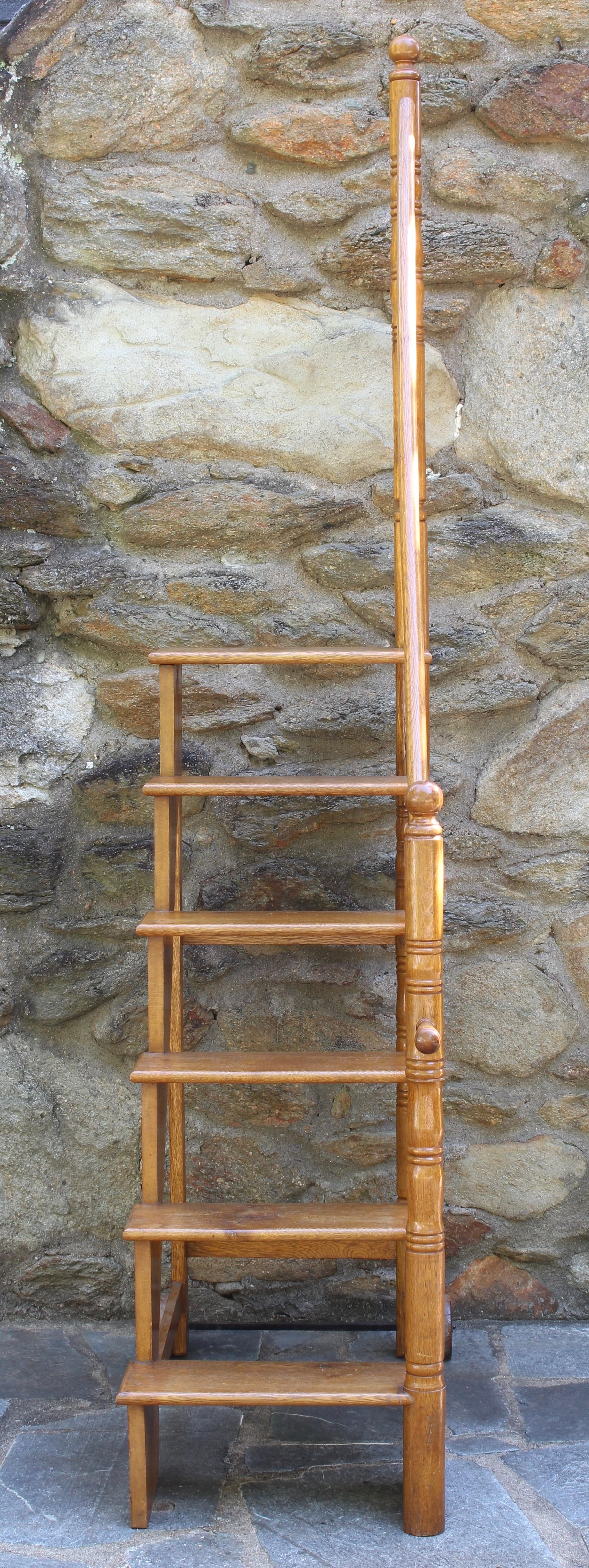 A large early 20th century English set of extremely sturdy and functional library steps handcrafted in English oak with handle and wheels to allow for easy movement.