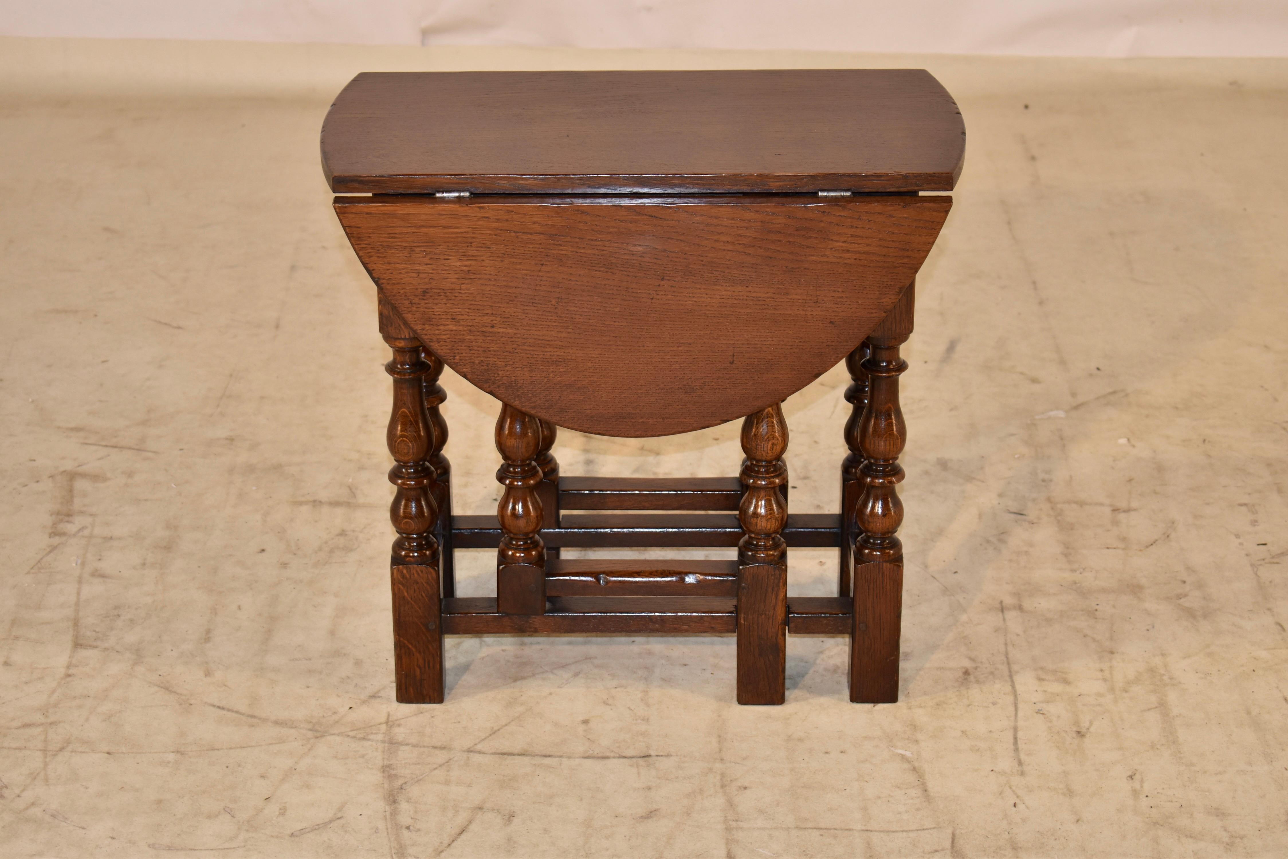 circa 1900-1909 English gate leg side table. This period Edwardian table has lovely graining on the top, following down to simple aprons, and supported on hand turned legs and gate legs. The legs are joined by simple stretchers. When the leaves are