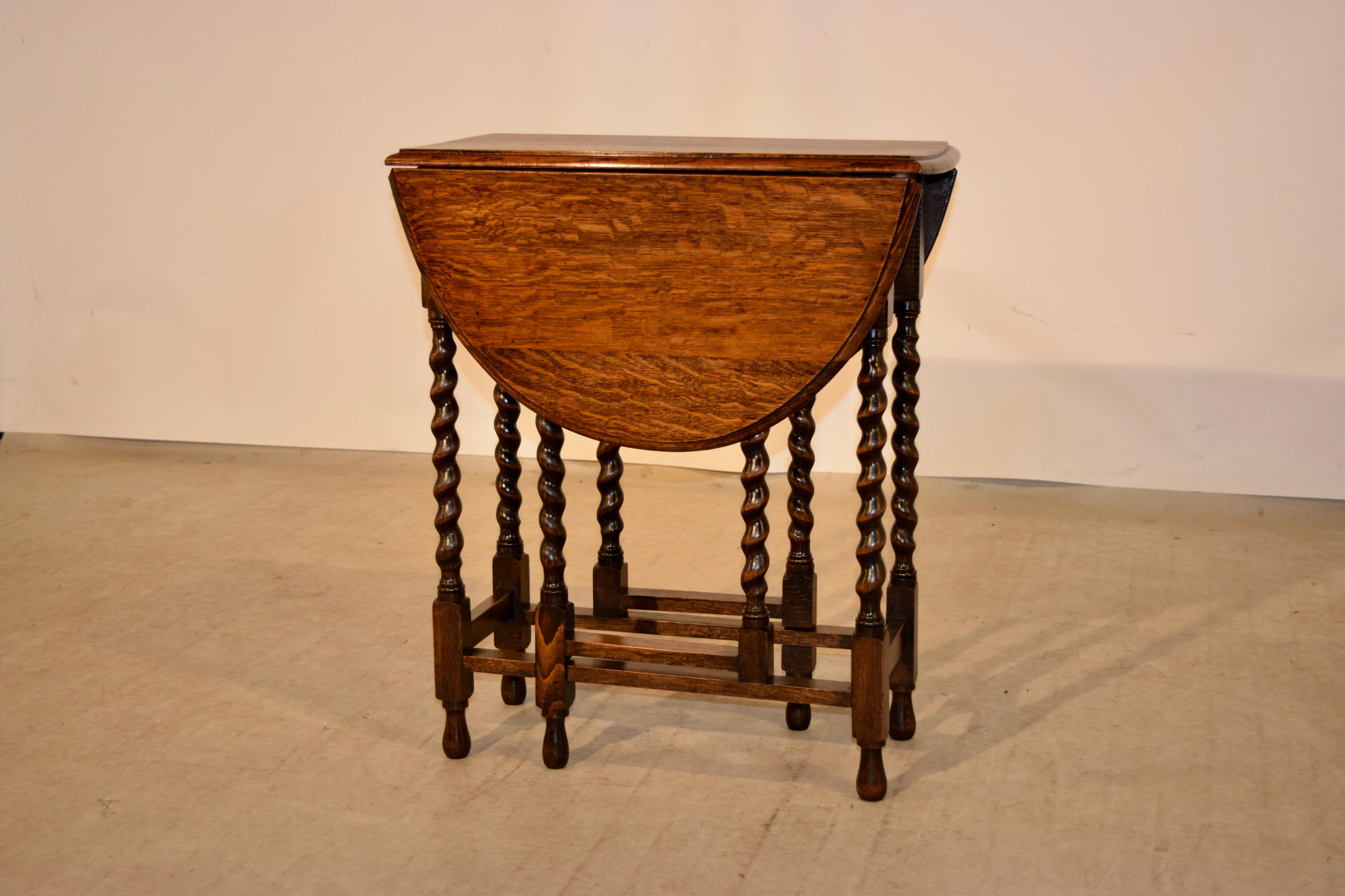 English oak gate leg table from England, circa 1900 with a beveled edge around the top, following down to a simple apron and hand turned barley twist legs, joined by simple stretchers. Supported on hand turned feet. Top open measures 35.75 x 24.5.