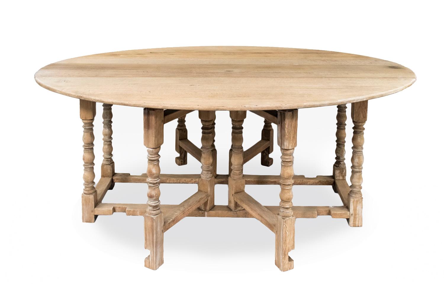 English in raw oak gateleg table standing on eight legs in baluster, discs and rectangular cubes shape : four fixed legs linked each other by four rectangular stretchers and four movable legs linked to pivots, with similar shape as the other