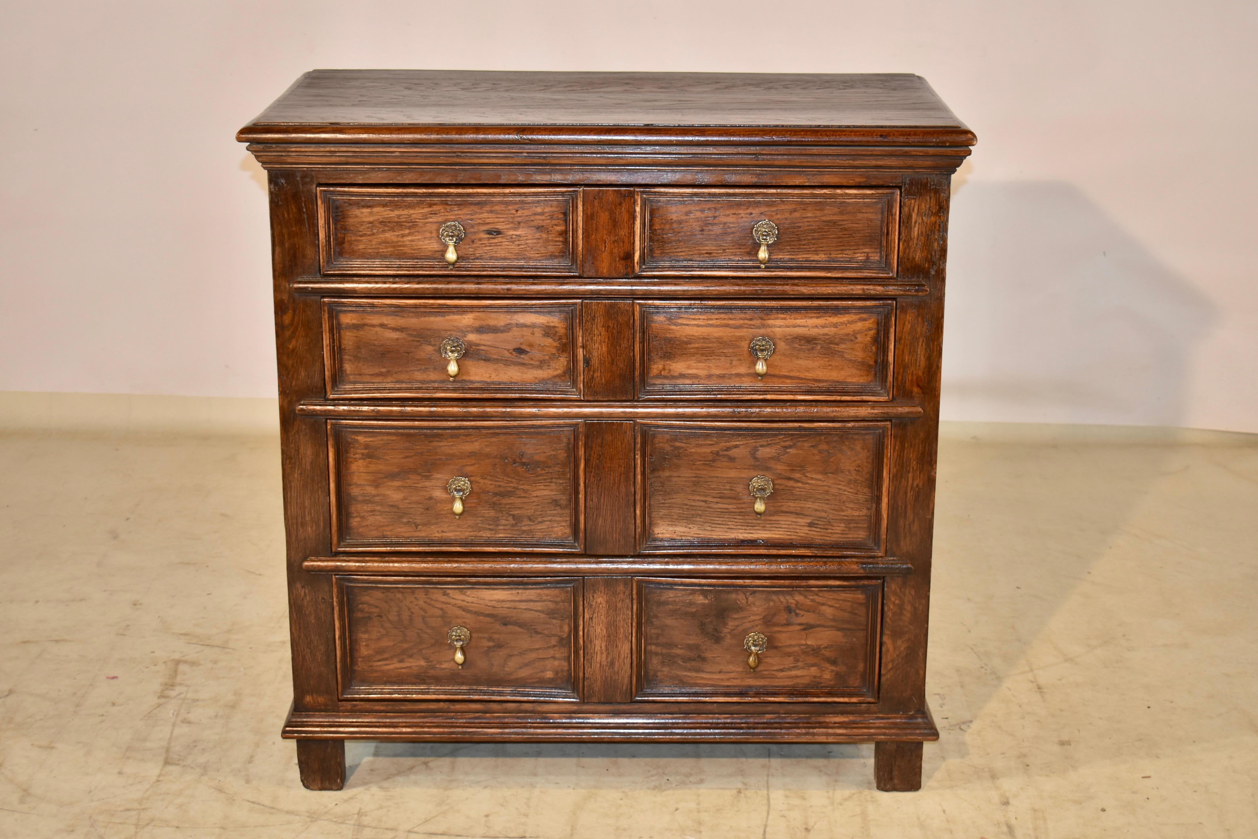 English oak geometric chest of drawers, circa 1940. The top has a beveled edge, over a molded edge, and follows down to simple paneled sides. The front of the case contains four drawers with raised paneled drawer fronts. The case has a molded base
