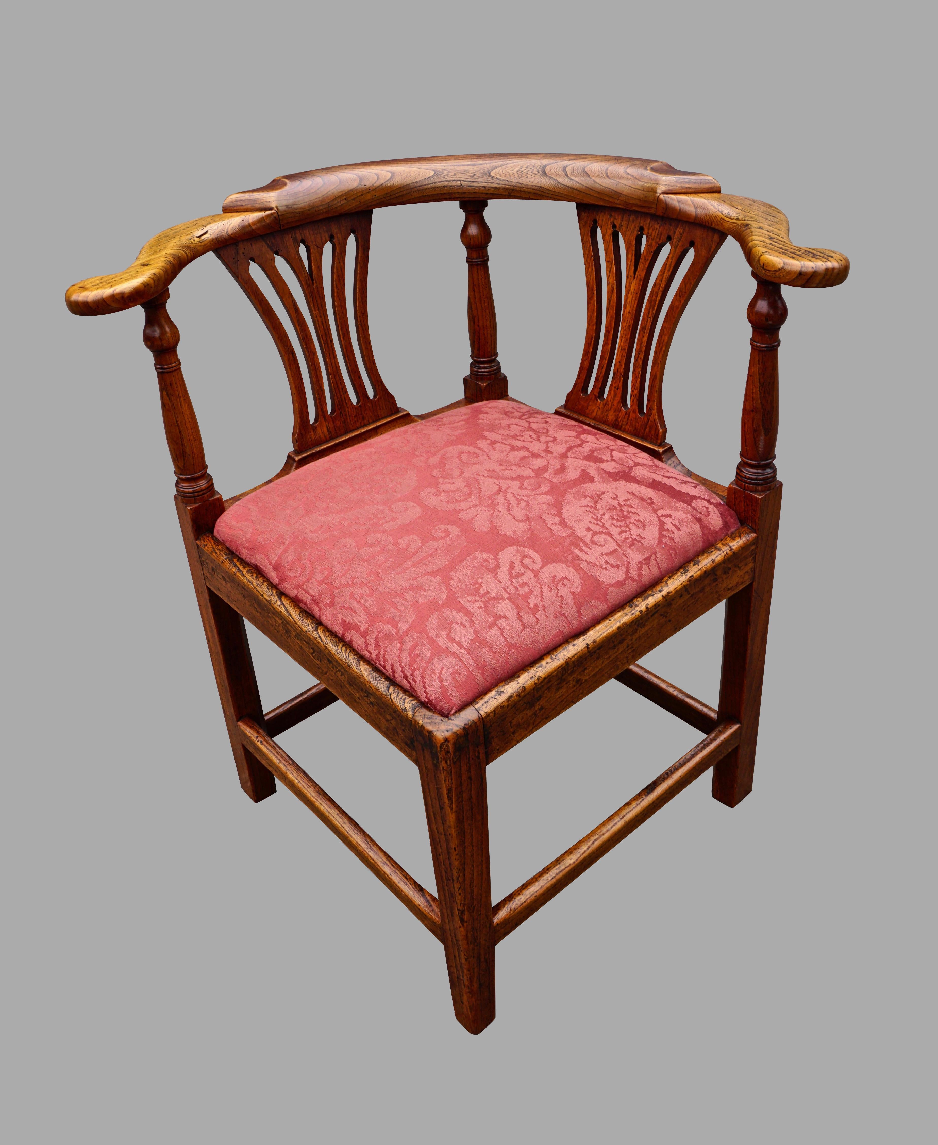 An English oak George III period corner chair with open splats, the attractive curved crestrail supported by 3 well-turned standards terminating in square legs joined by a box stretcher. Mellow color and finish. Circa 1800.