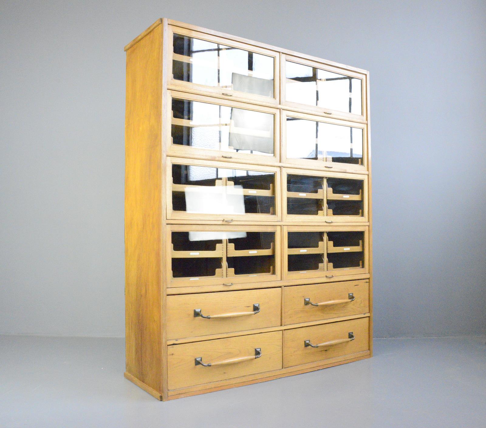 English oak haberdashery cabinet, circa 1920s

- Oak frame and drawers
- 4 large drawers with oak and cast bronze handles
- 36 smaller drawers
- Lift down windows
- Oak veneer sides
- English, 1920s
- Measures: 152cm wide x 192cm tall x 52cm