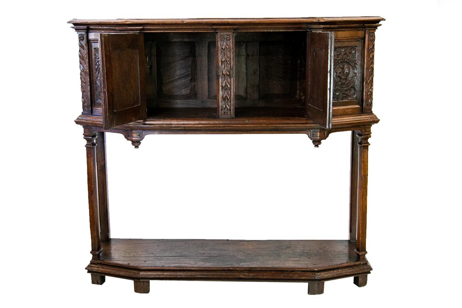 English Oak Jacobean style court cupboard has double peg construction and the original steel strap hinges and locking latches.There are six carved panels on the front and sides depicting bust surrounded by stylized birds and arabesques. The drawers