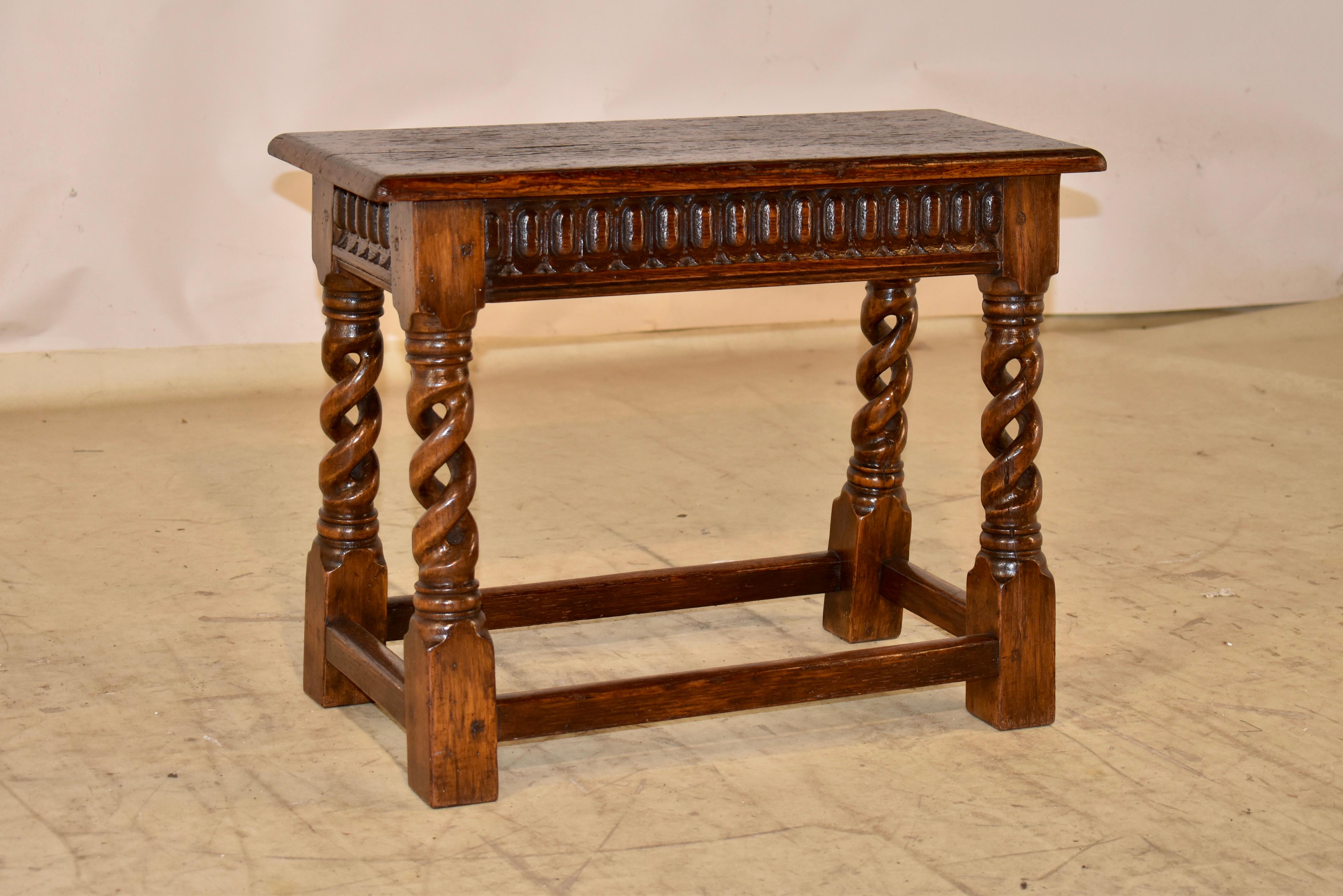 Eichenholzhocker aus der Edwardianischen Zeit aus England.  Die Platte ist aus einem einzigen Brett gefertigt und hat eine schöne Maserung.  Daran schließt sich eine handgeschnitzte Schürze an.  Die Schürze ist an allen vier Seiten geschnitzt und
