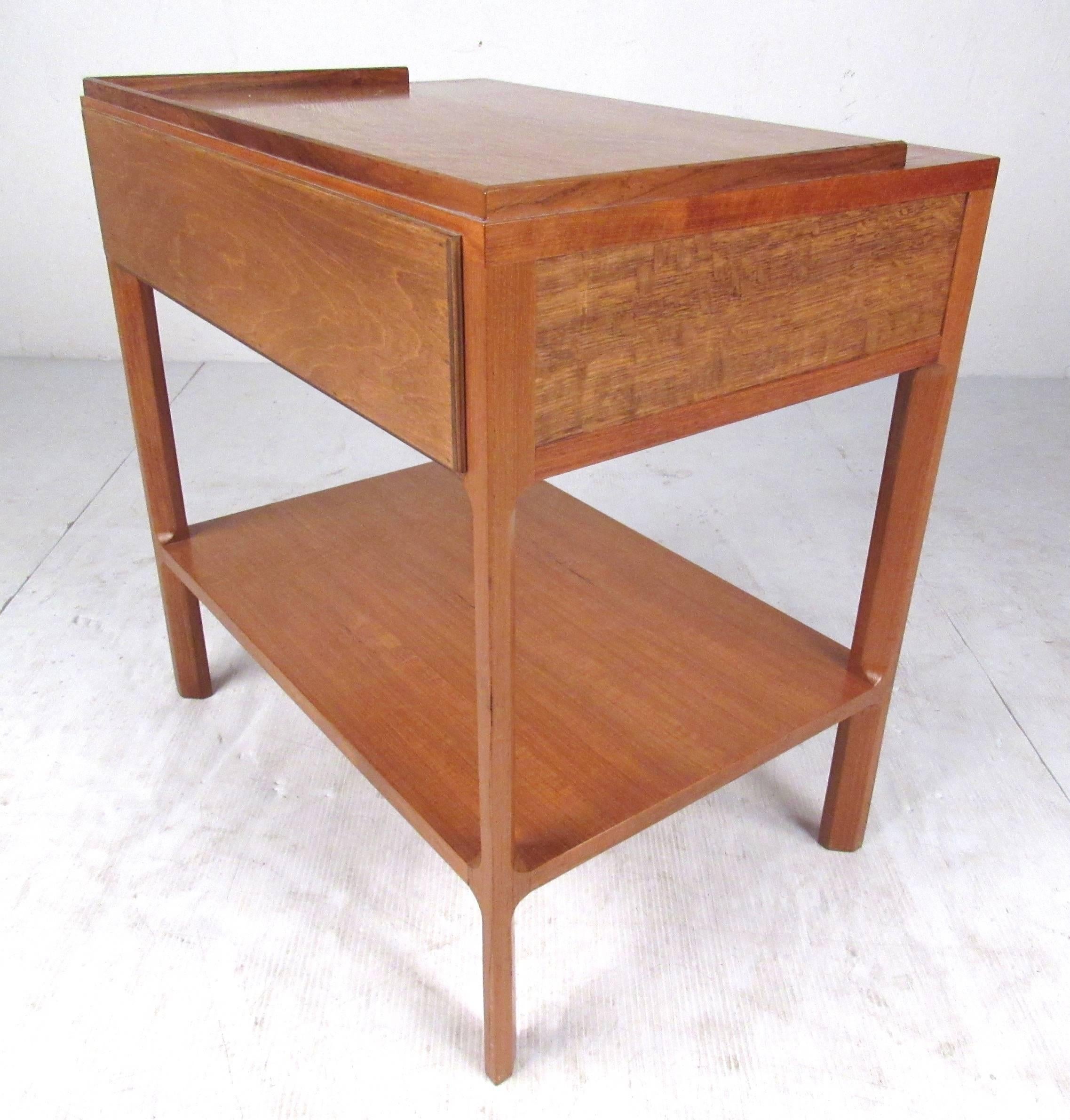 Single drawer side table or nightstand by Dunbar, 1971. Comprised of English oak, teak and rosewood, this beautifully detailed table is in very good condition with the original shipping label still attached. Please confirm item location (NY or NJ)