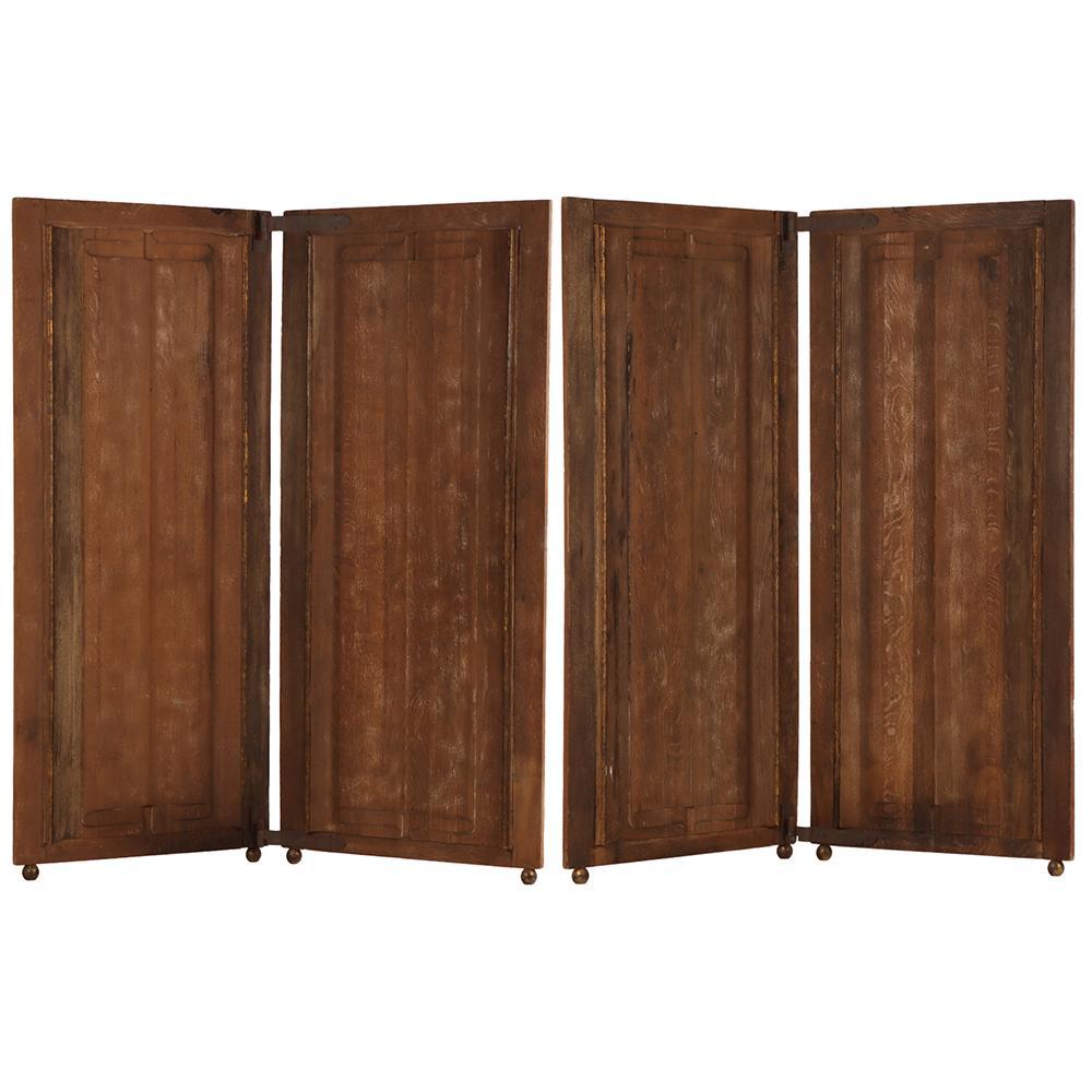 A handsome English oak four-panel folding screen crafted from doors with classic linenfold carving and later-added small turned feet. This piece may function as a room divider, decorative backdrop, or architectural accent. The addition of finely