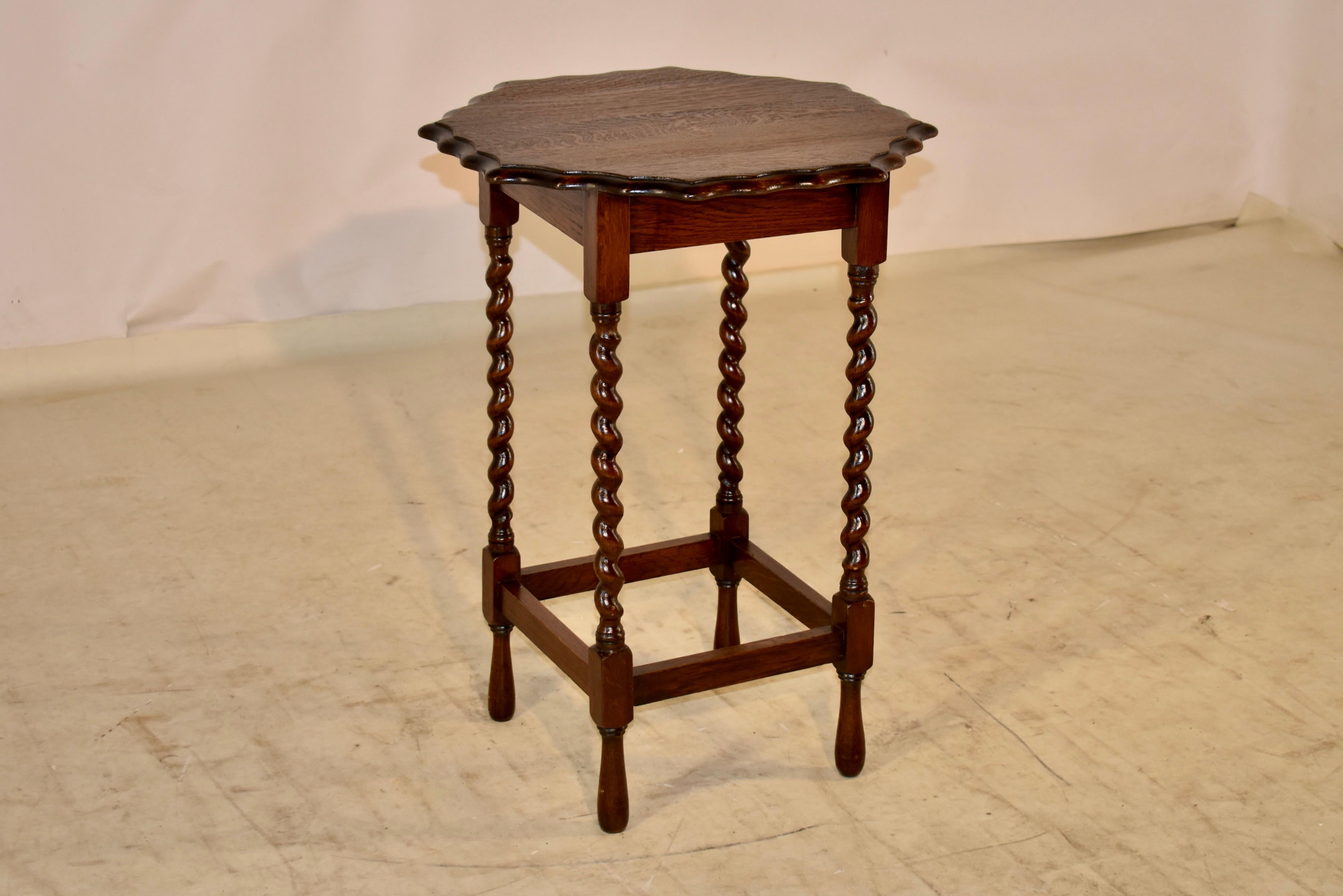 Circa 1900 Edwardian oak side table. The top is an octagonal shape and has lovely beveled and scalloped edges, following down to a simple apron and supported on hand turned barley twist legs, joined by simple stretchers. The table is raised on hand