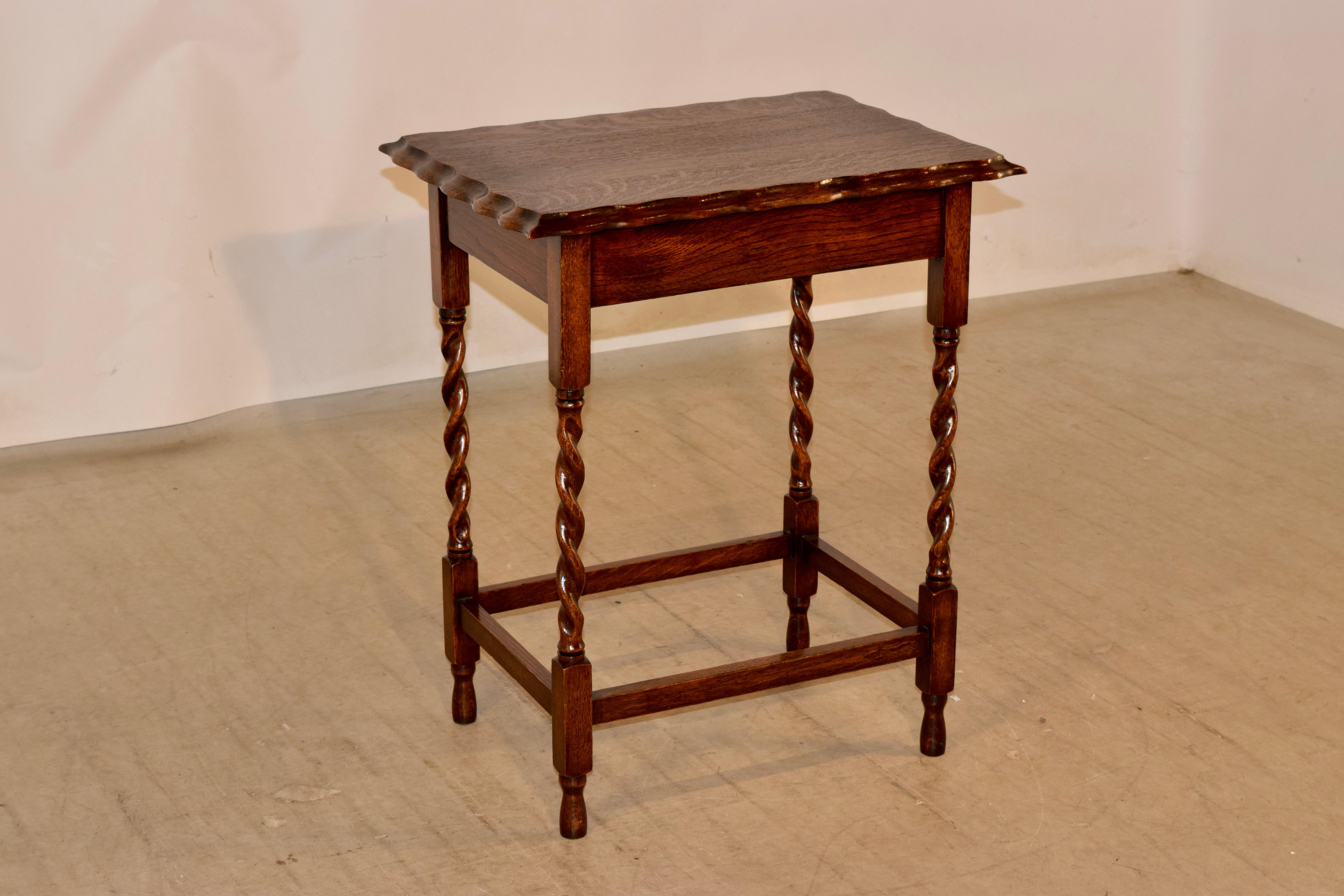 English oak occasional table, circa 1900. the top has an exquisitely scalloped and beveled edge around the top over a simple apron and supported on hand turned barley twist legs, joined by simple stretchers and raised on turned feet.