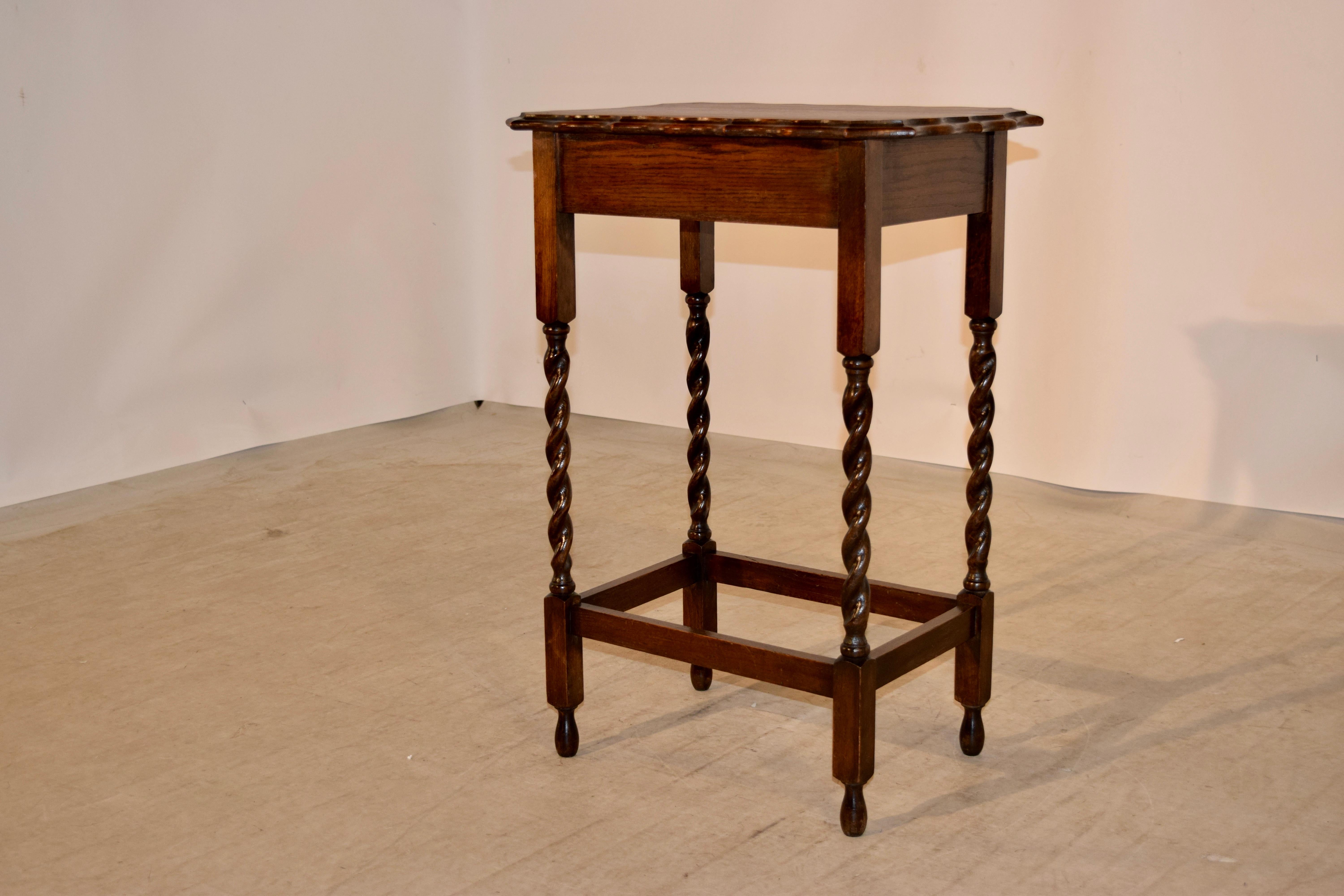 English oak side table with an exquisitely scalloped and beveled edge following down to a simple apron and supported on hand turned barley twist legs joined by stretchers and raised on hand turned feet, circa 1900.